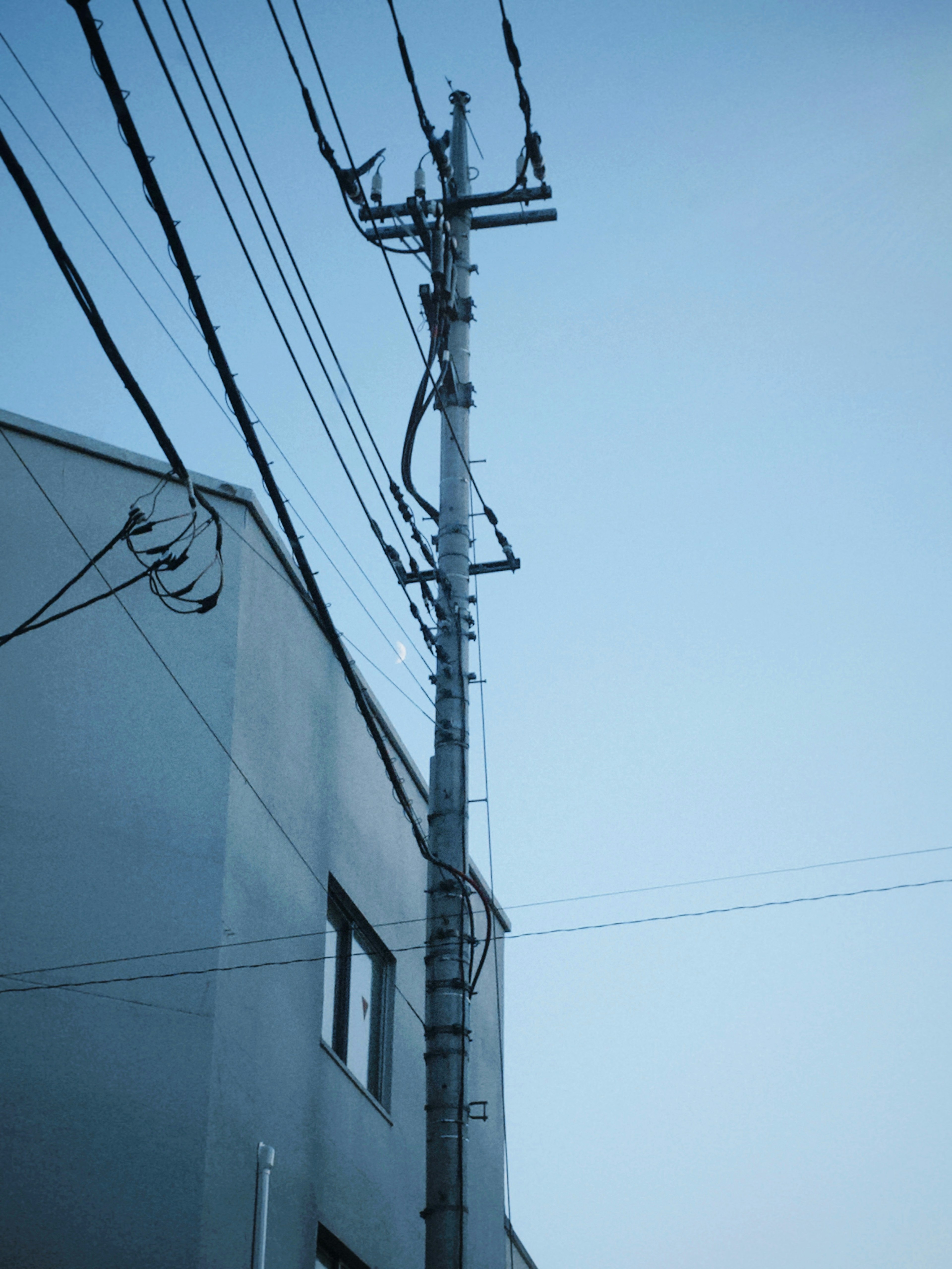 Utility pole and power lines against a blue sky