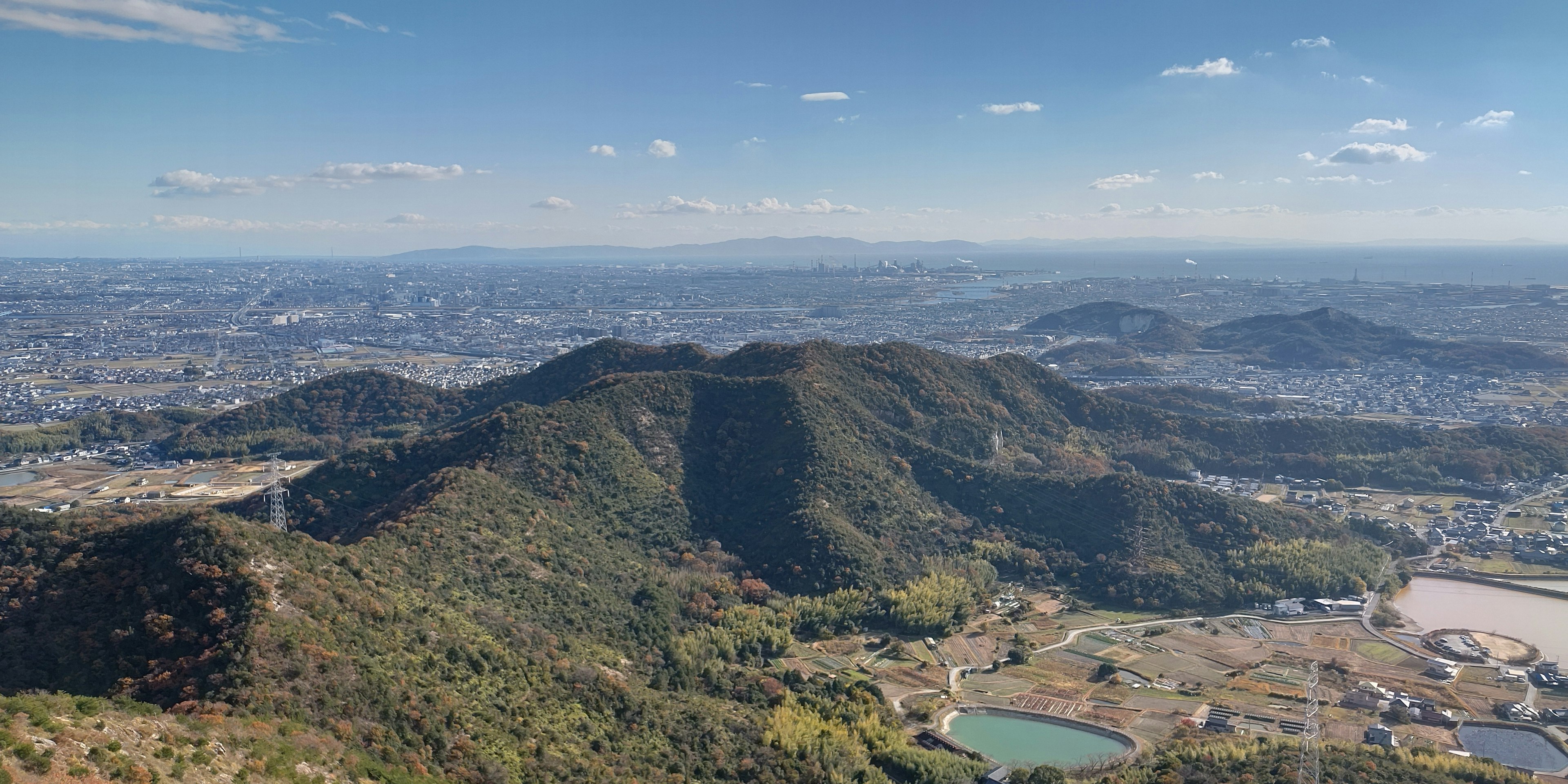 山々と都市の景色が広がる空撮風景