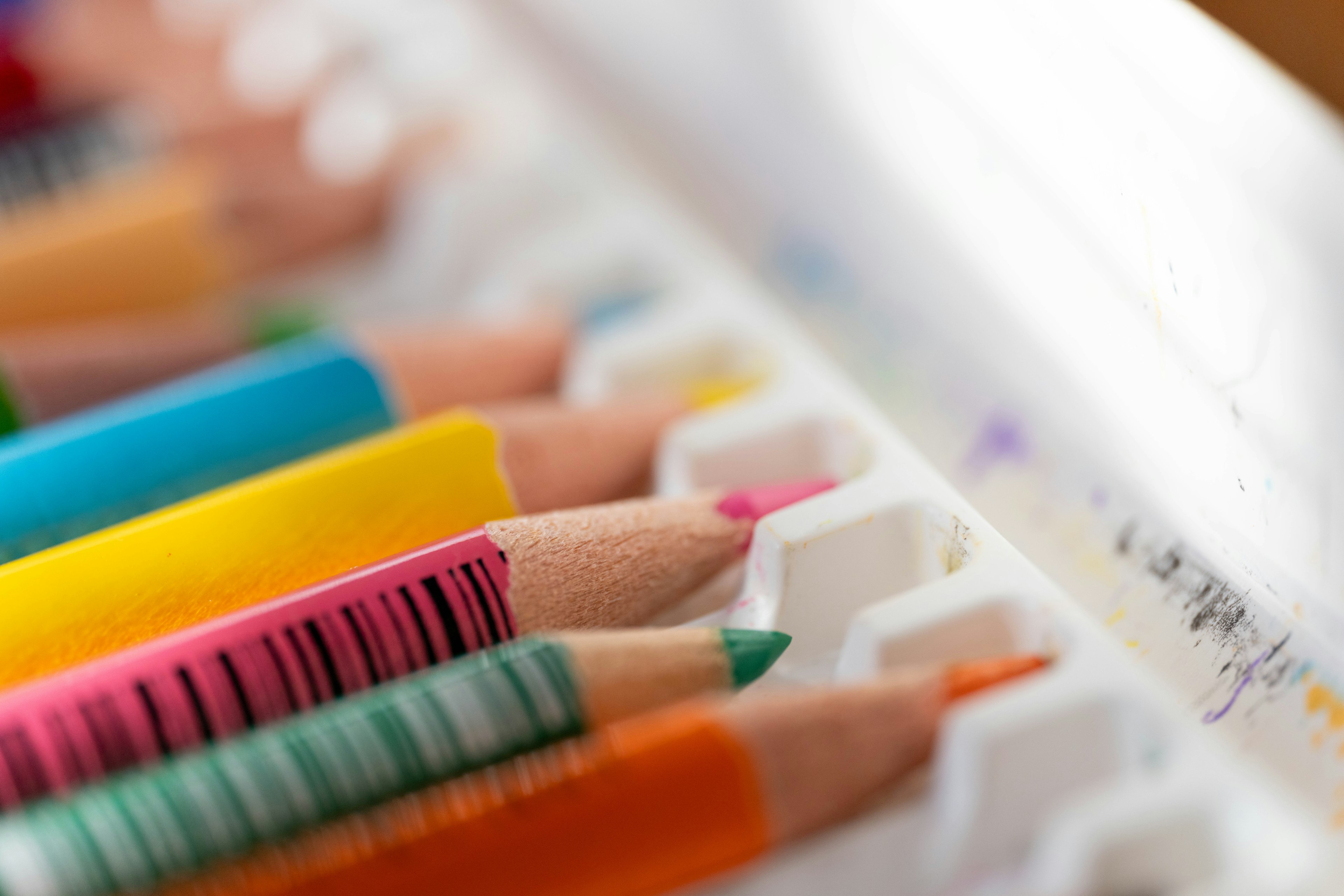 Close-up of colorful colored pencils arranged in a tray