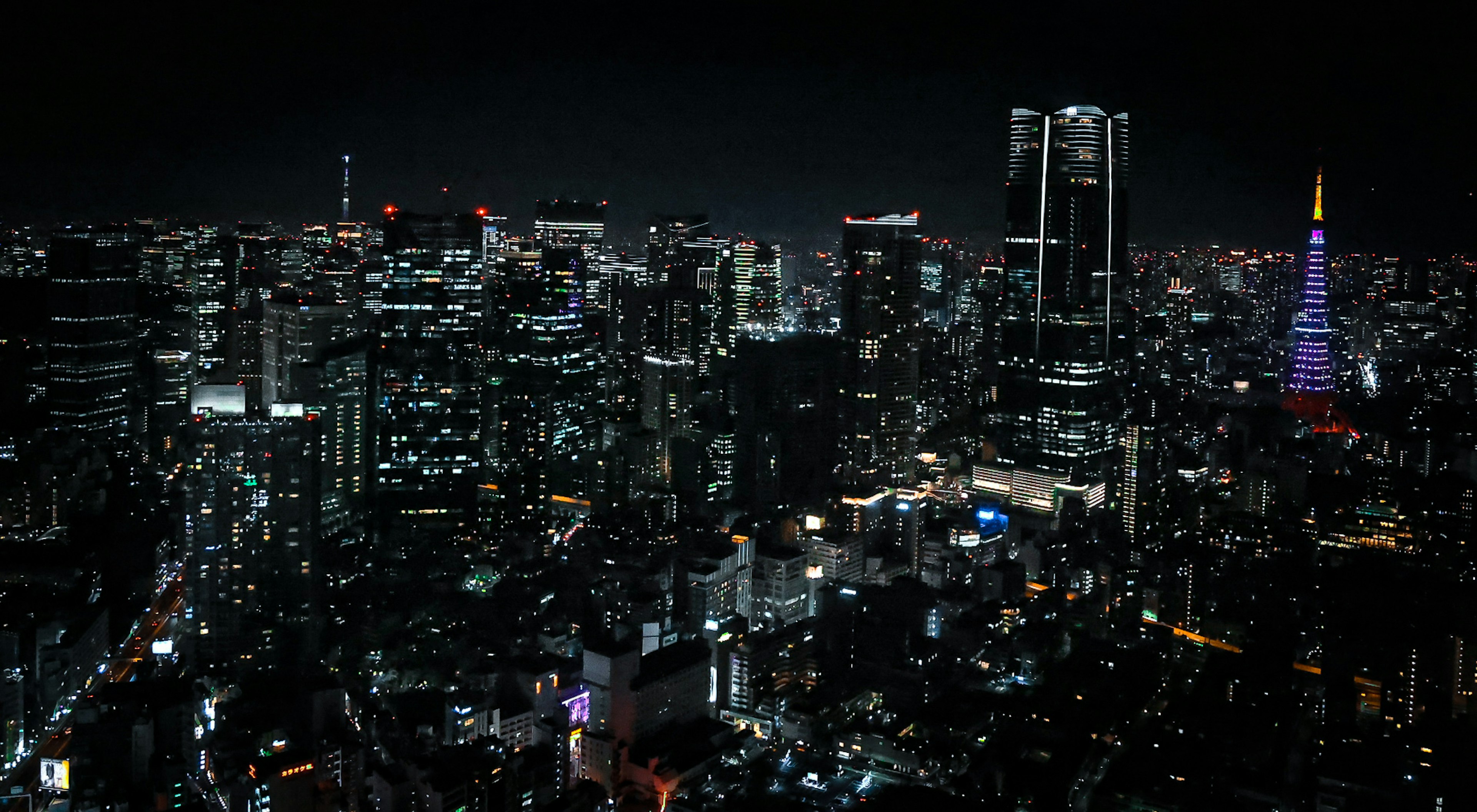 Garis langit malam Tokyo dengan gedung pencakar langit dan lautan cahaya dengan Menara Tokyo yang diterangi