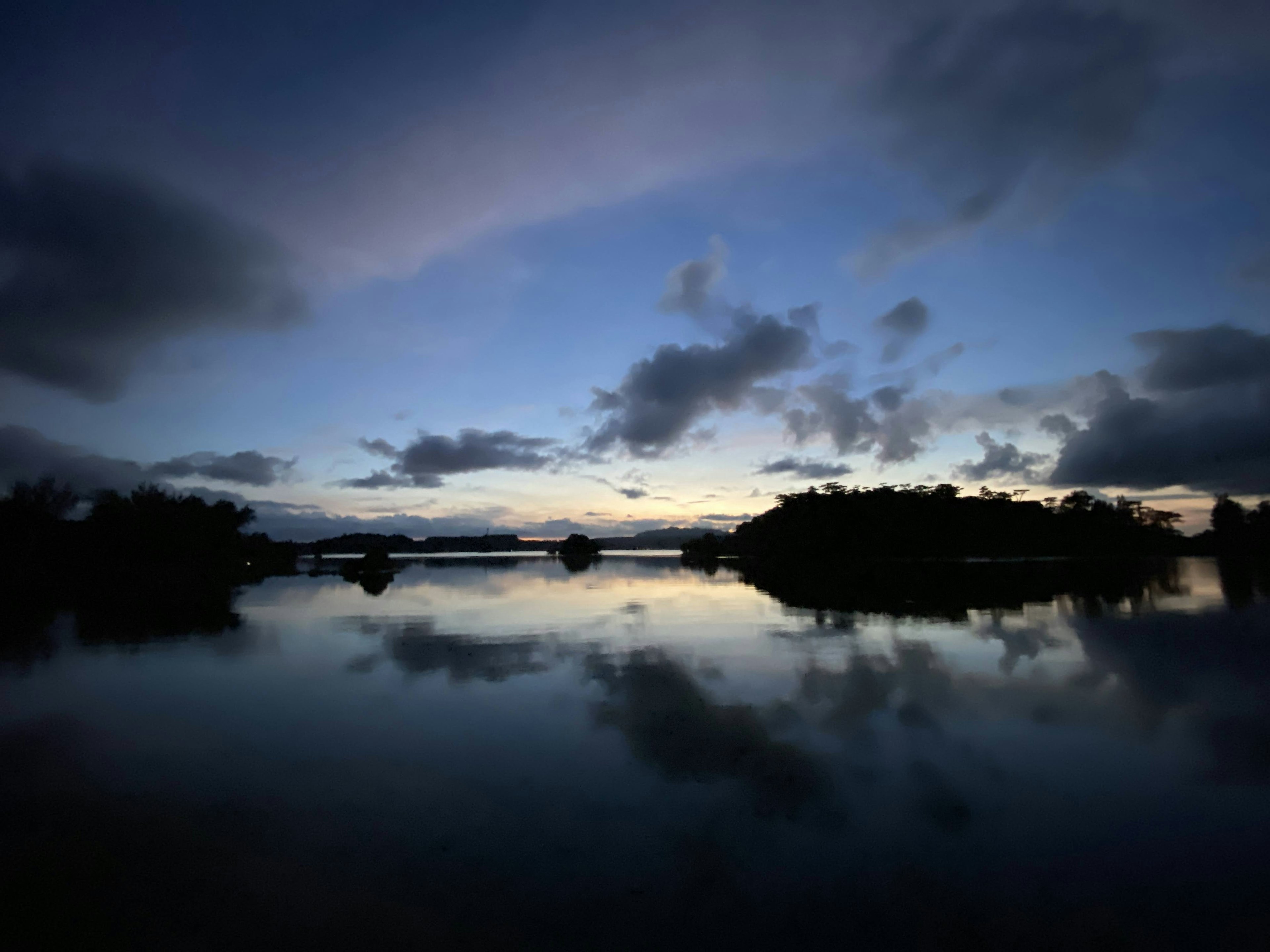 Lac calme au crépuscule reflétant des nuages et la surface de l'eau