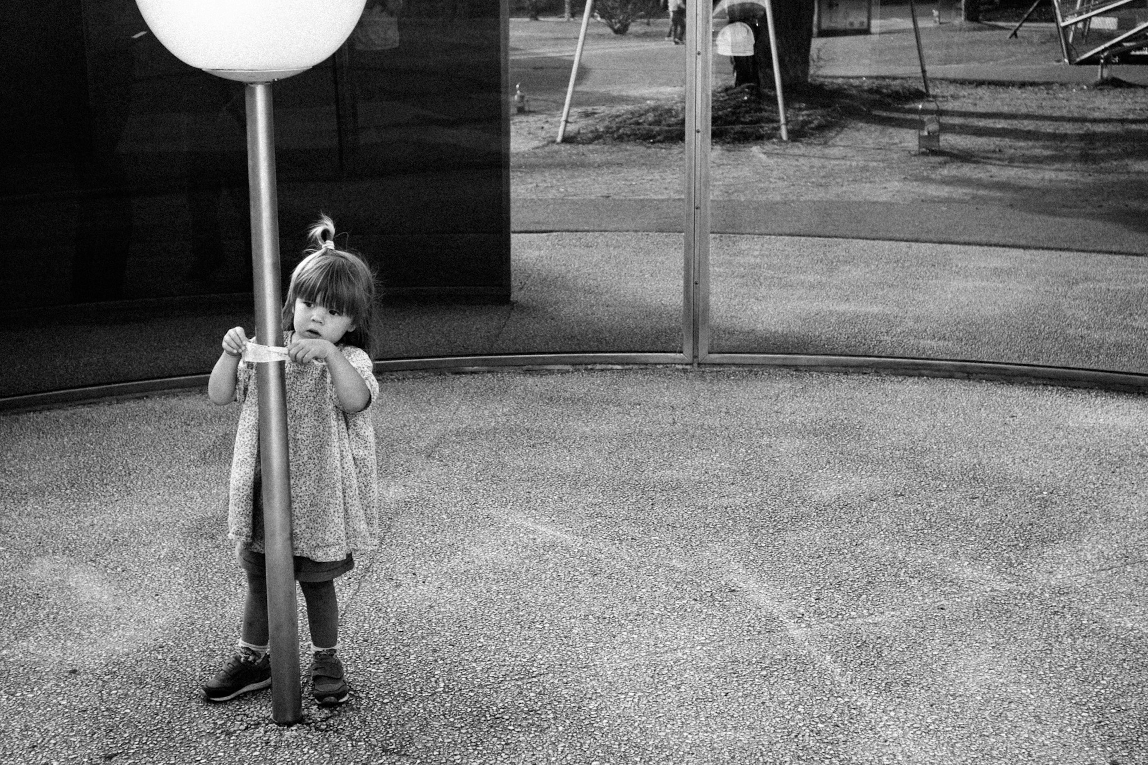 Child holding a pole in a playground setting