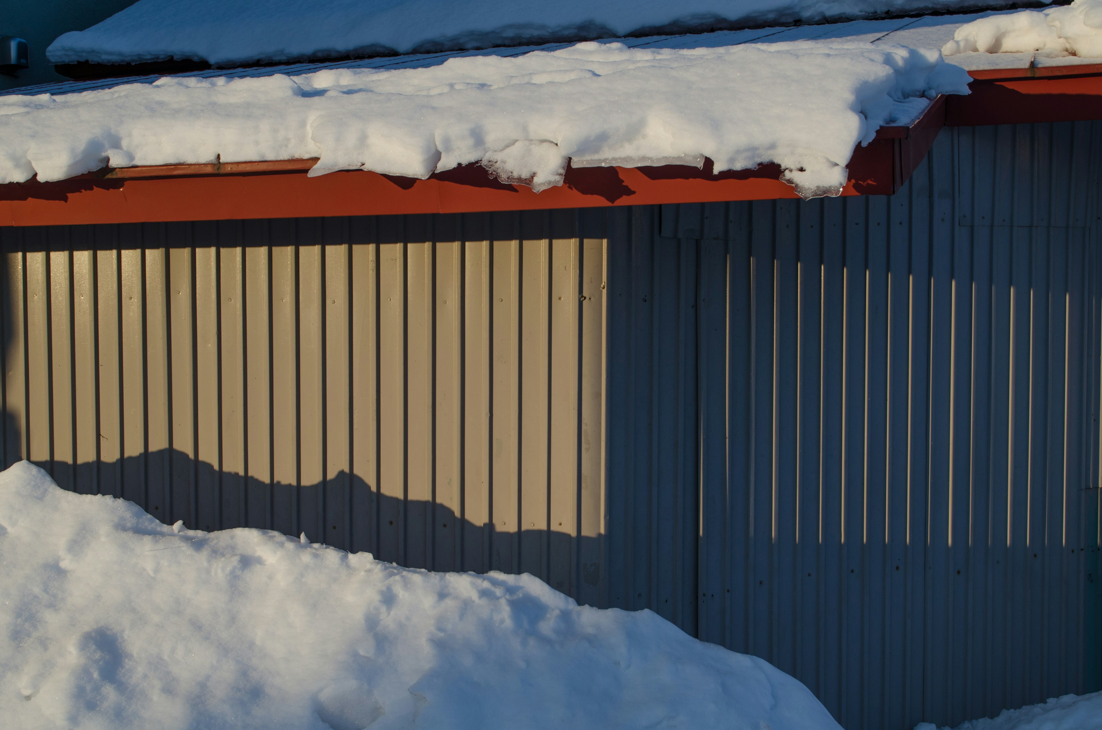 Detailed view of a snow-covered roof and exterior wall