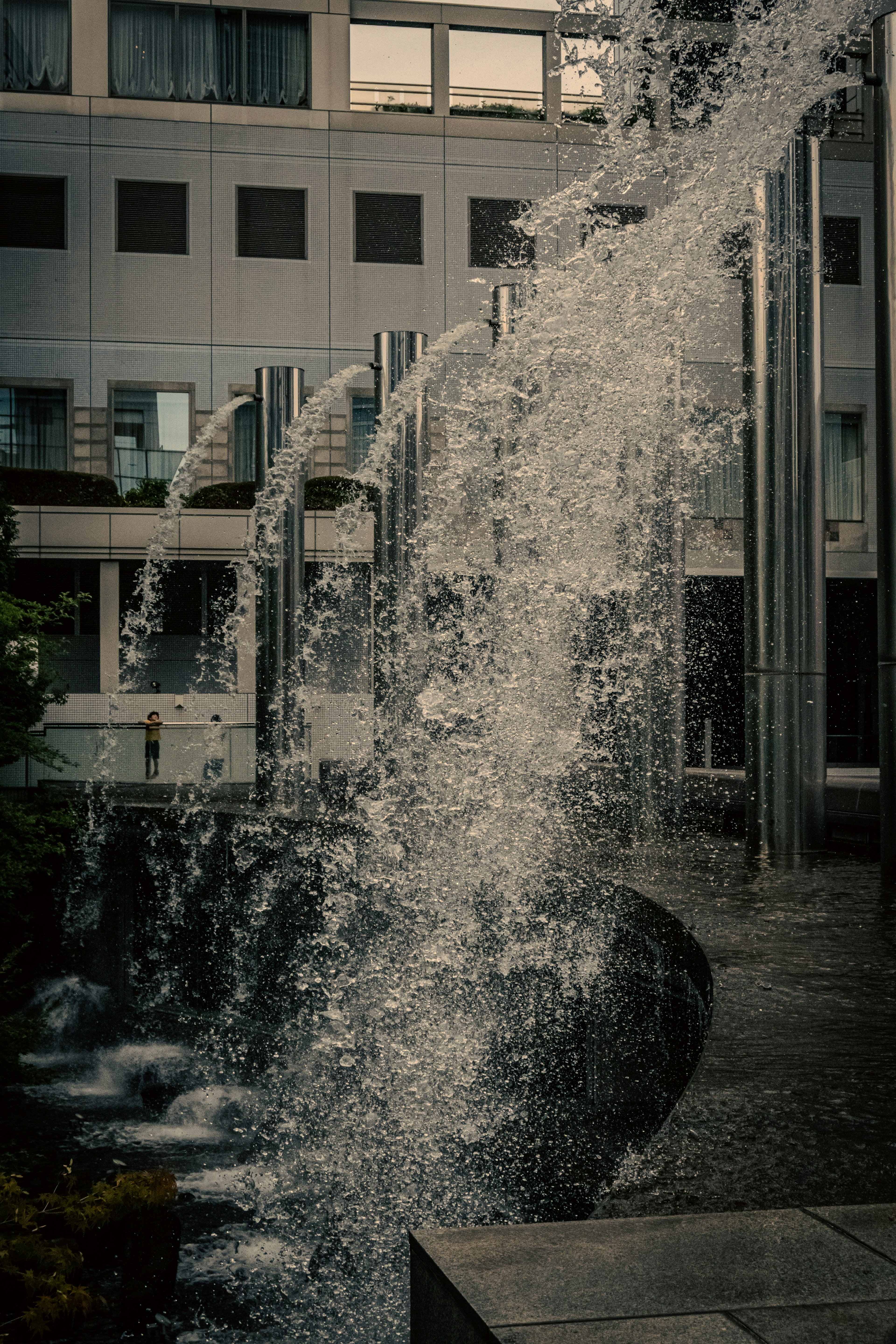 Modern water feature cascading down with a building backdrop