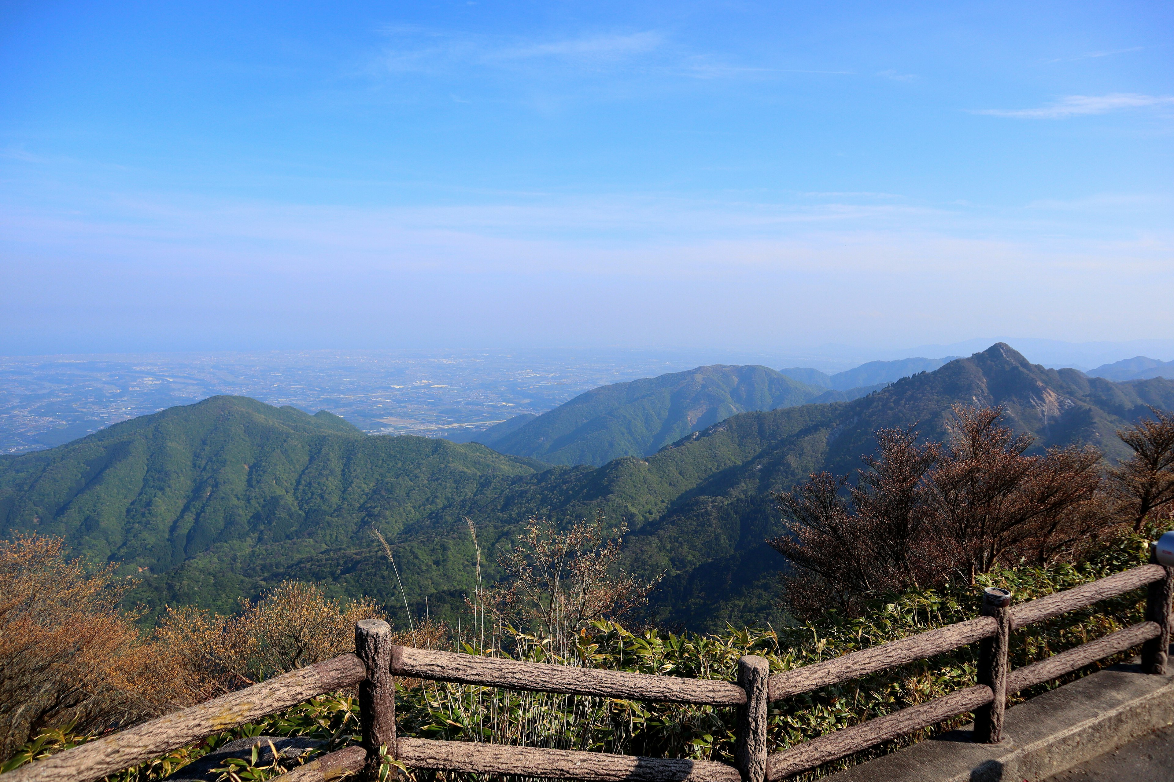 藍天下木柵欄旁的綠色山脈風景