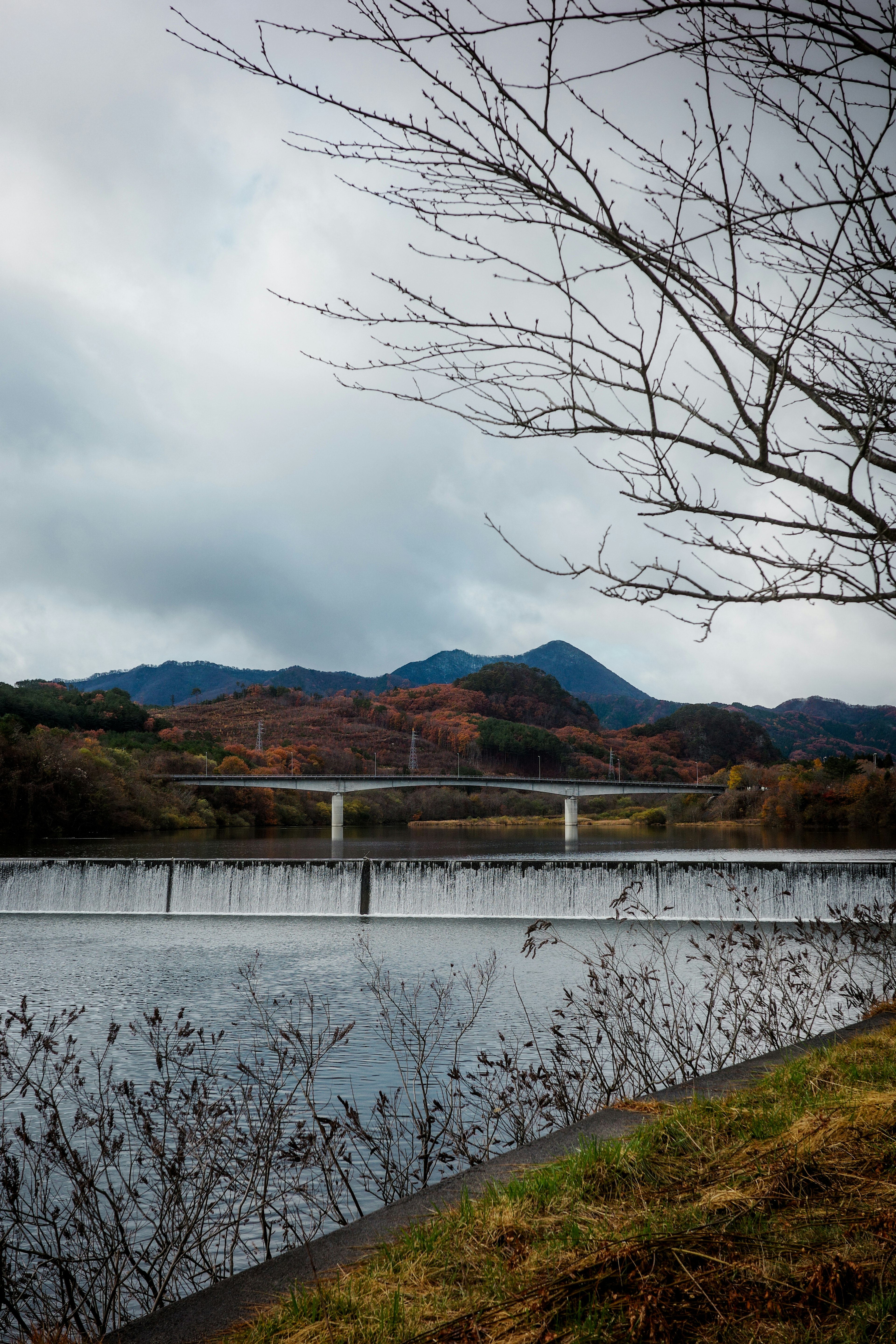 寧靜的河流和橋的風景 背景中有山和多雲的天空