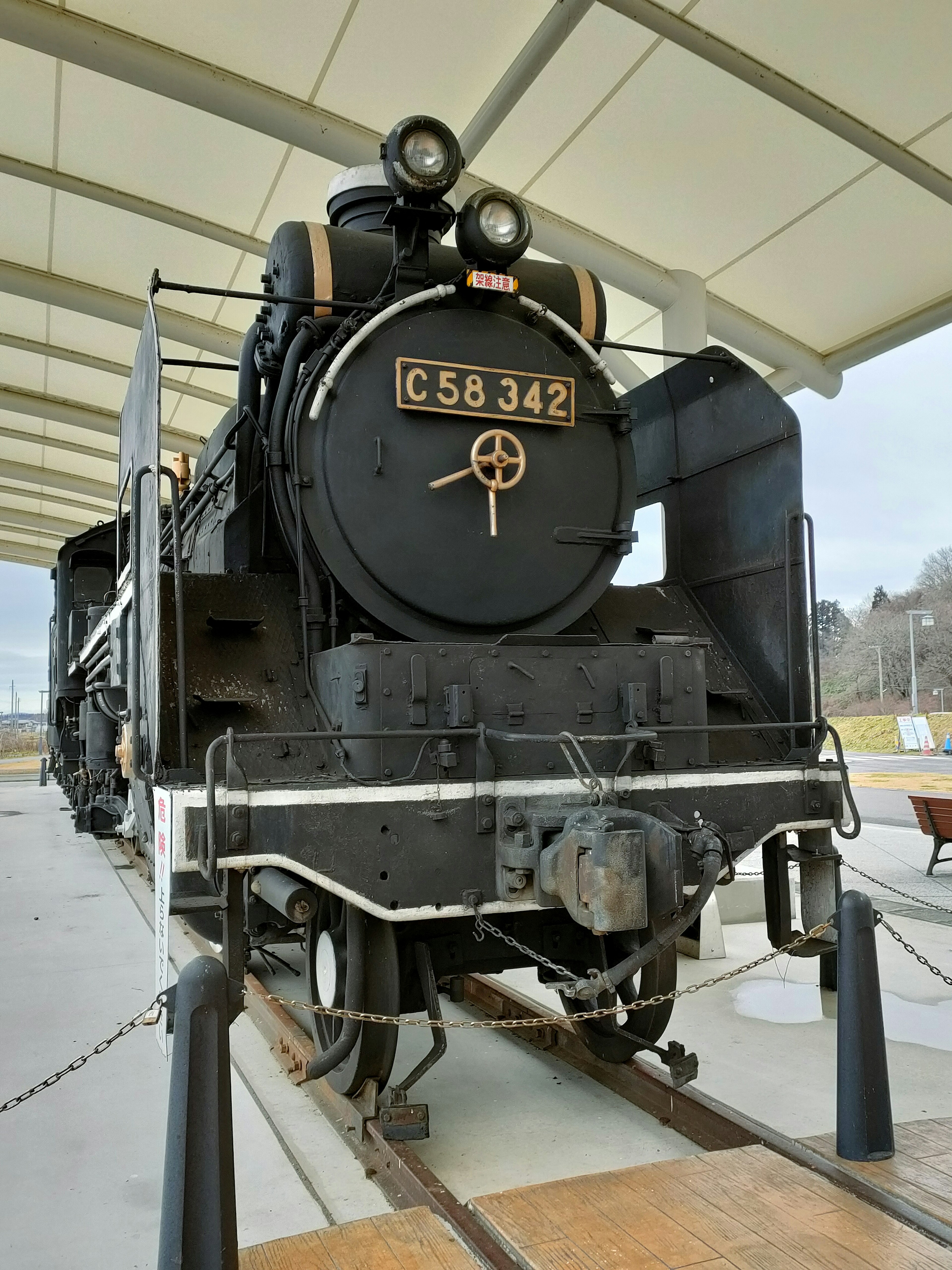 Locomotive à vapeur noire C58372 exposée dans un espace d'exposition couvert