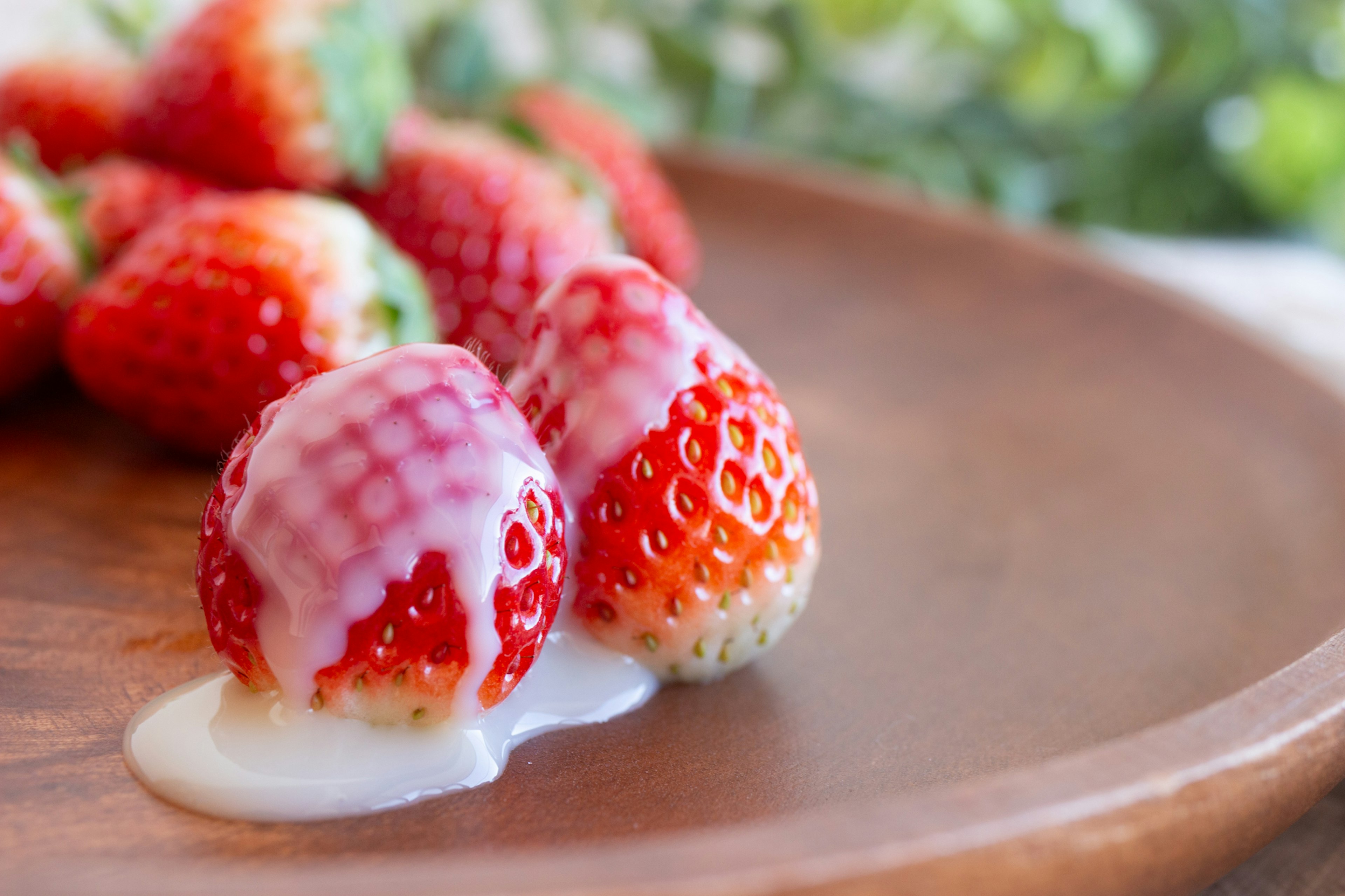 Strawberries with cream on a wooden plate