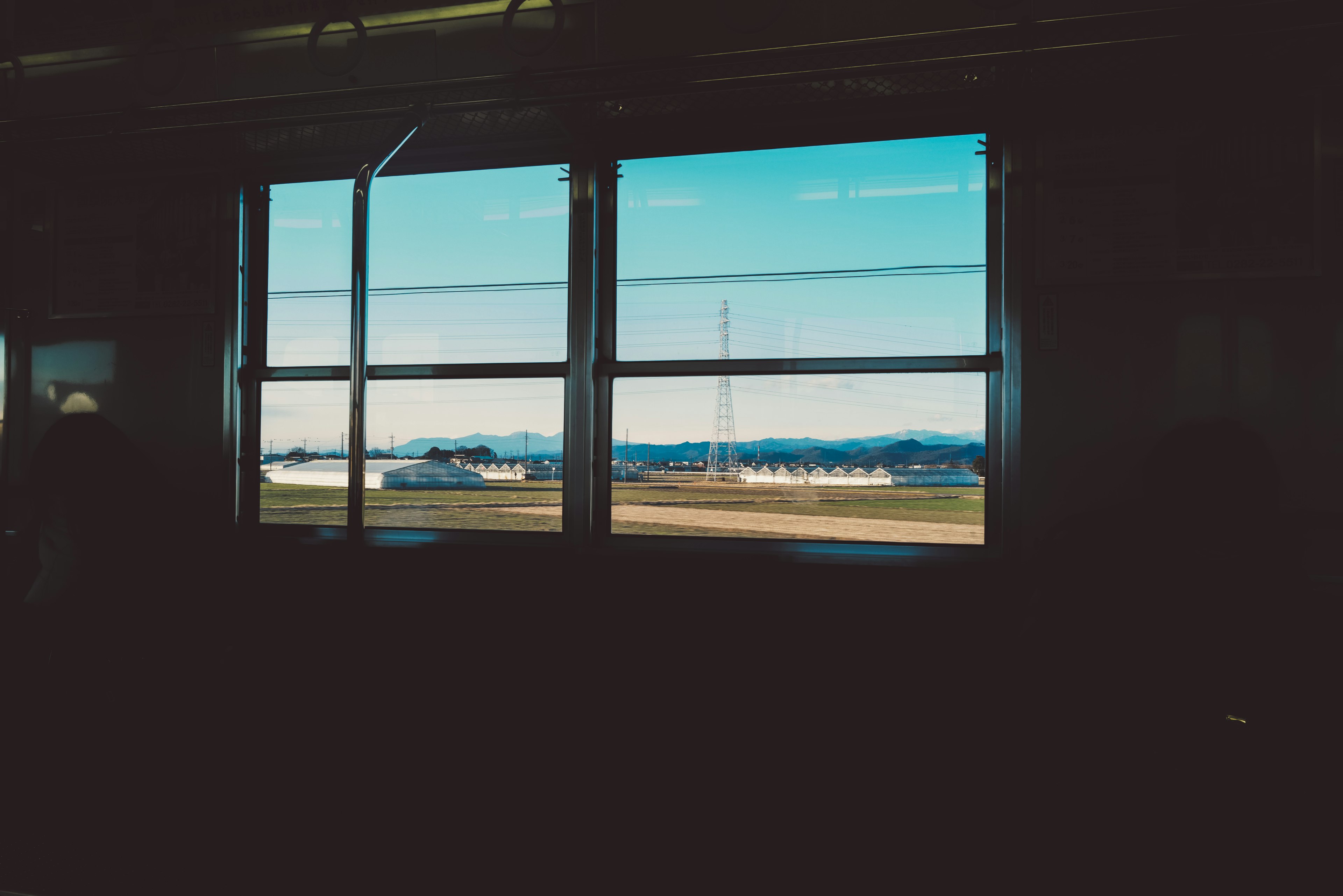 Vista del cielo azul y las montañas desde una ventana de tren