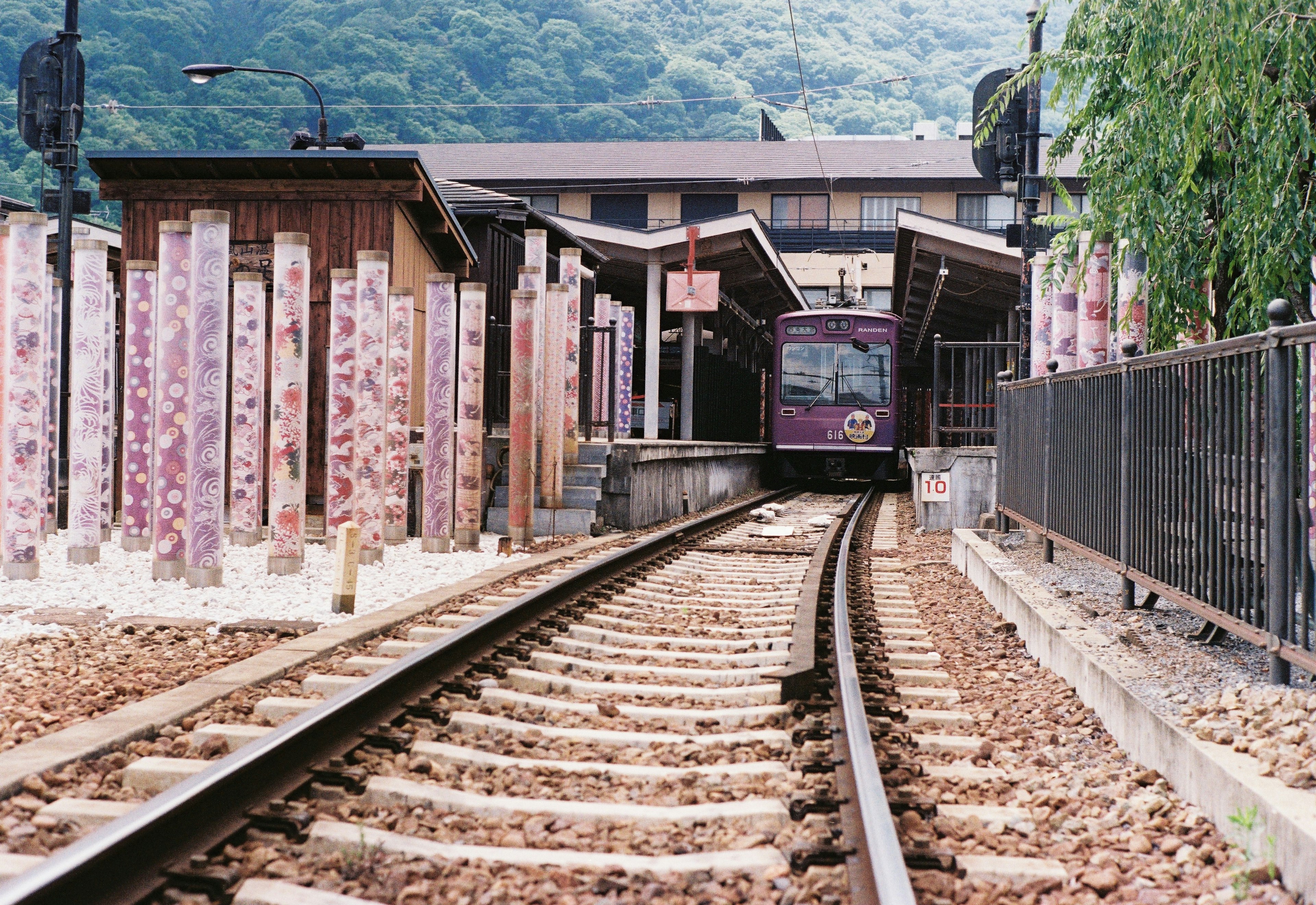 Treno in arrivo a una stazione di montagna con piattaforma in legno