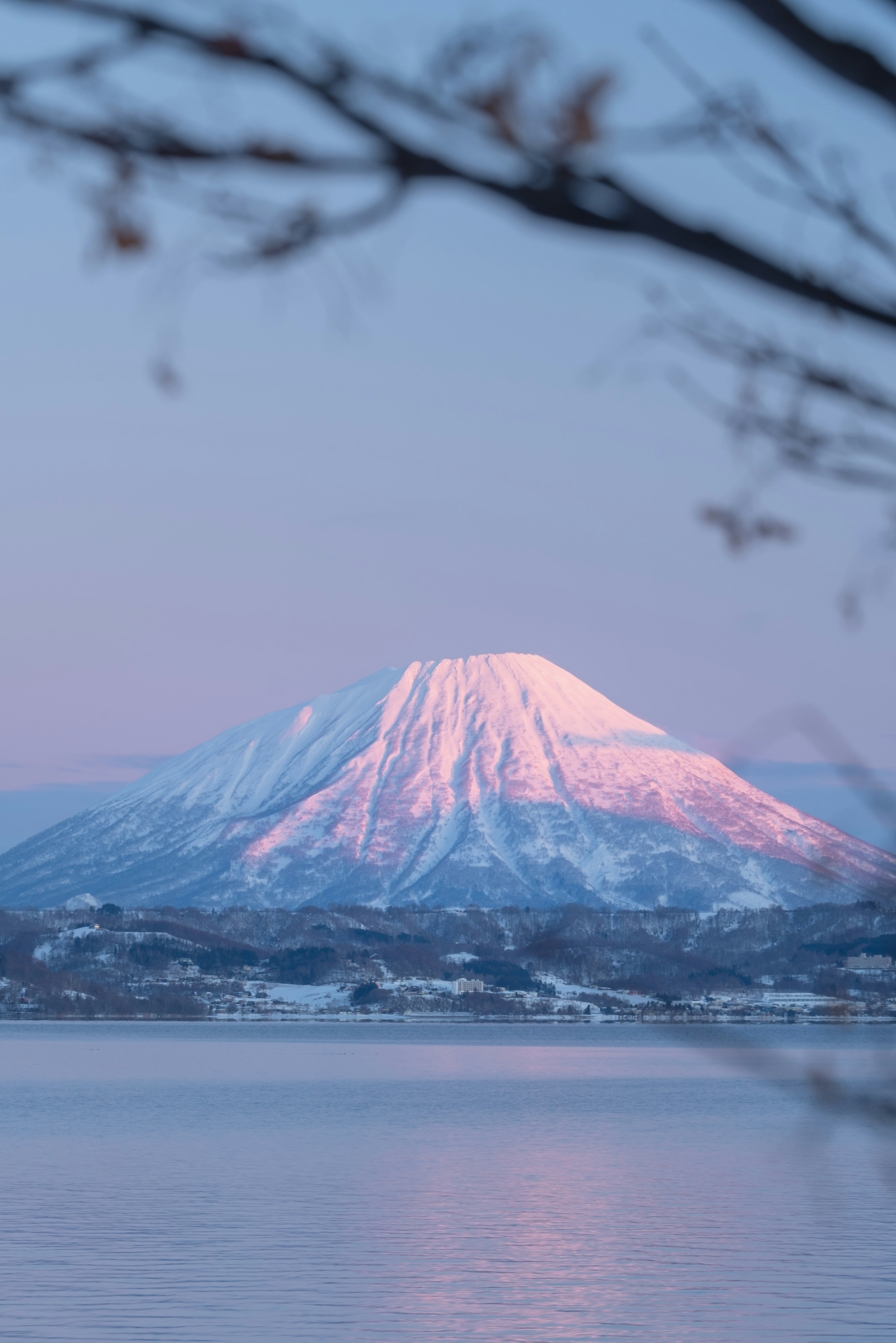 雪に覆われた美しい山が夕焼けの光に照らされている