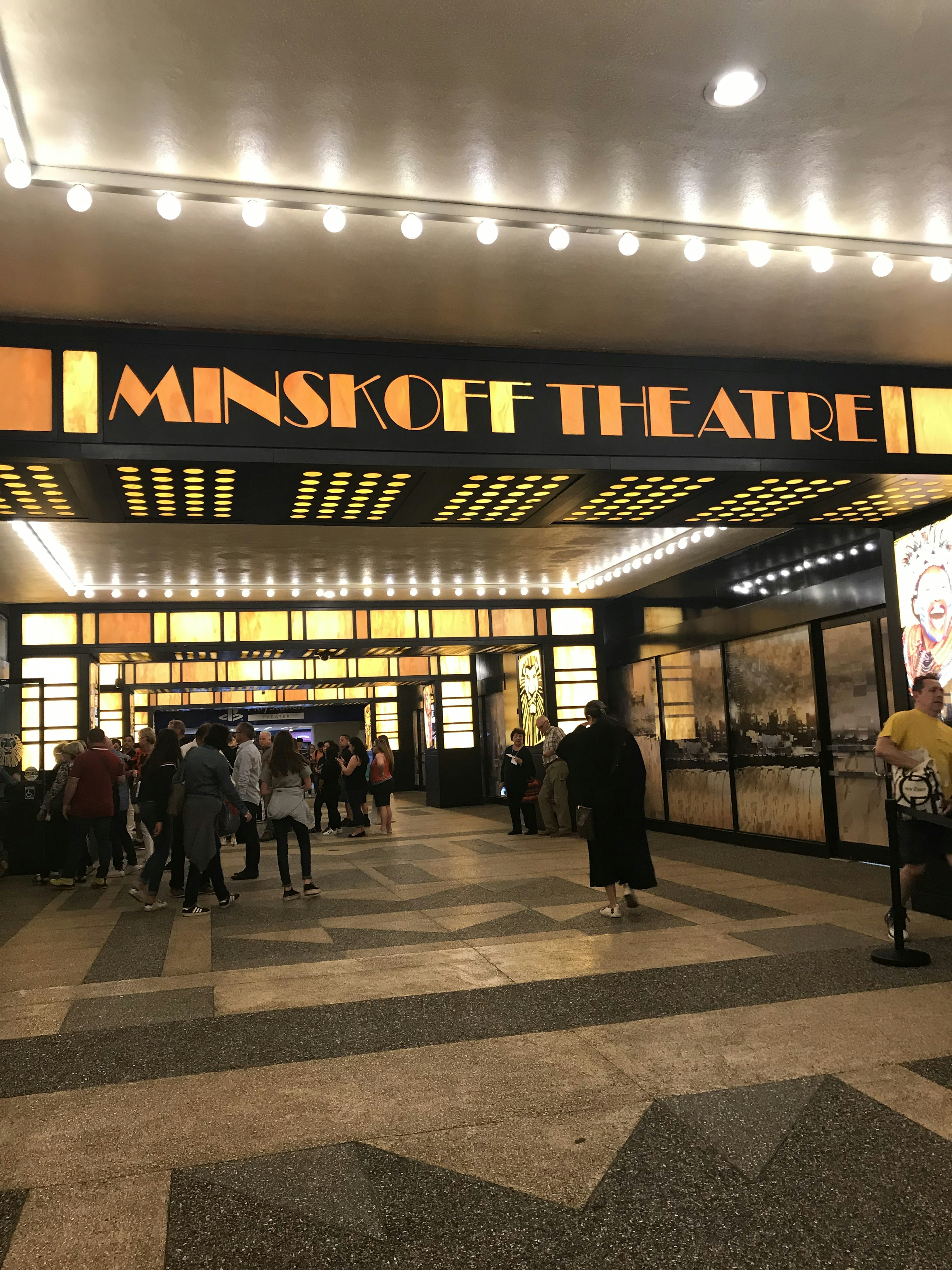 Lối vào của Minskoff Theatre đông đúc khách tham quan đèn sáng và người đi lại