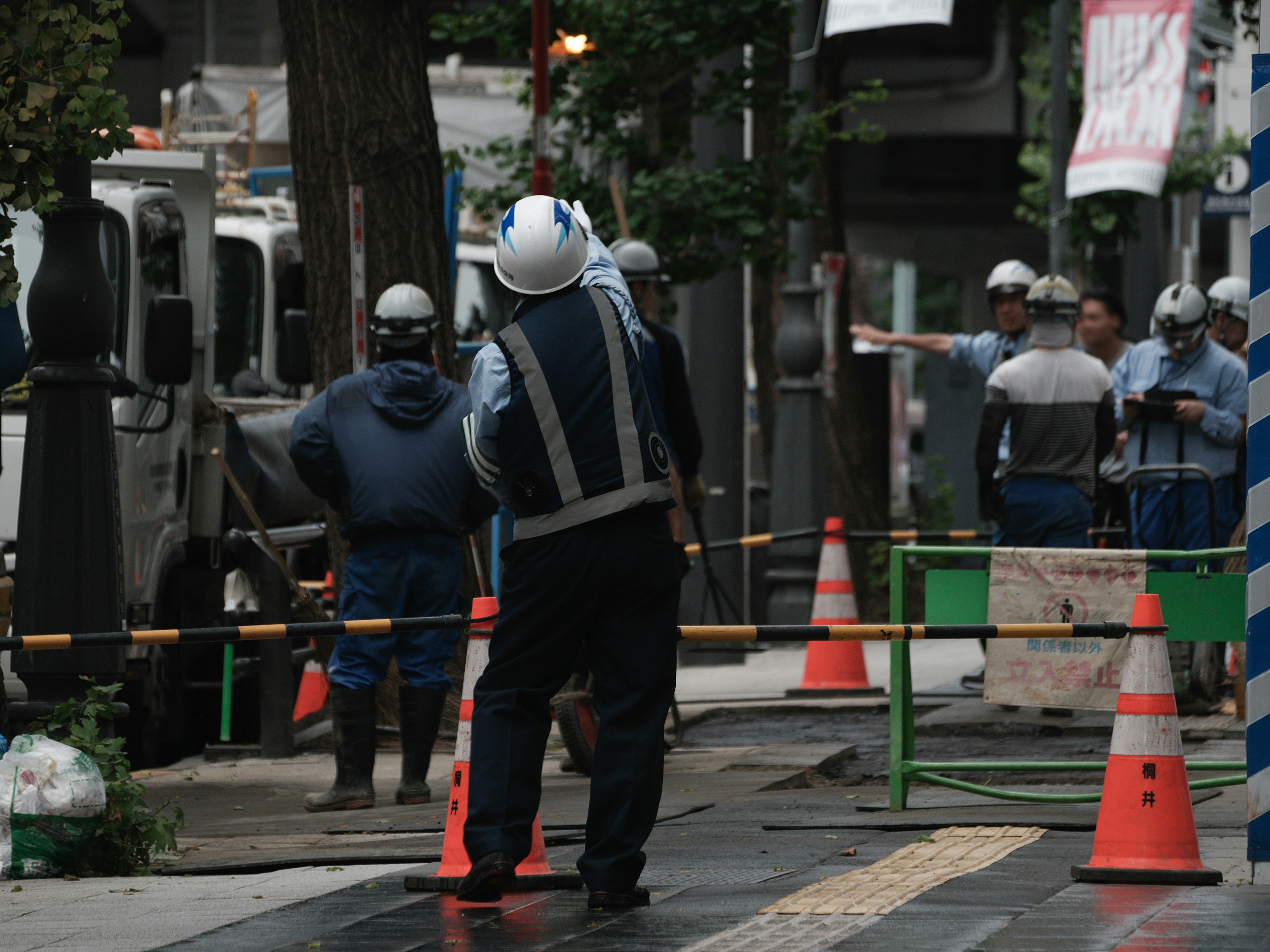 Workers in helmets engaged in construction work on a city street