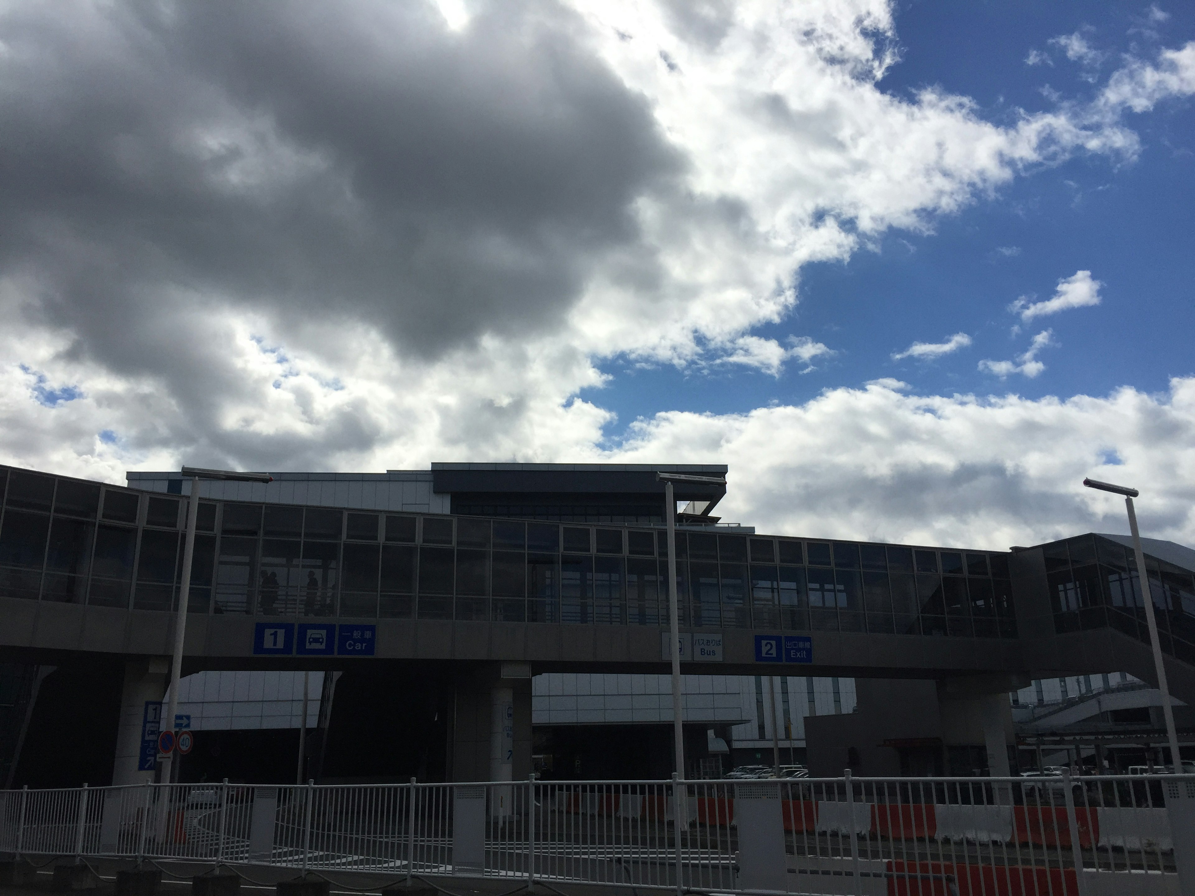 Extérieur d'un bâtiment moderne sous un ciel bleu avec des nuages