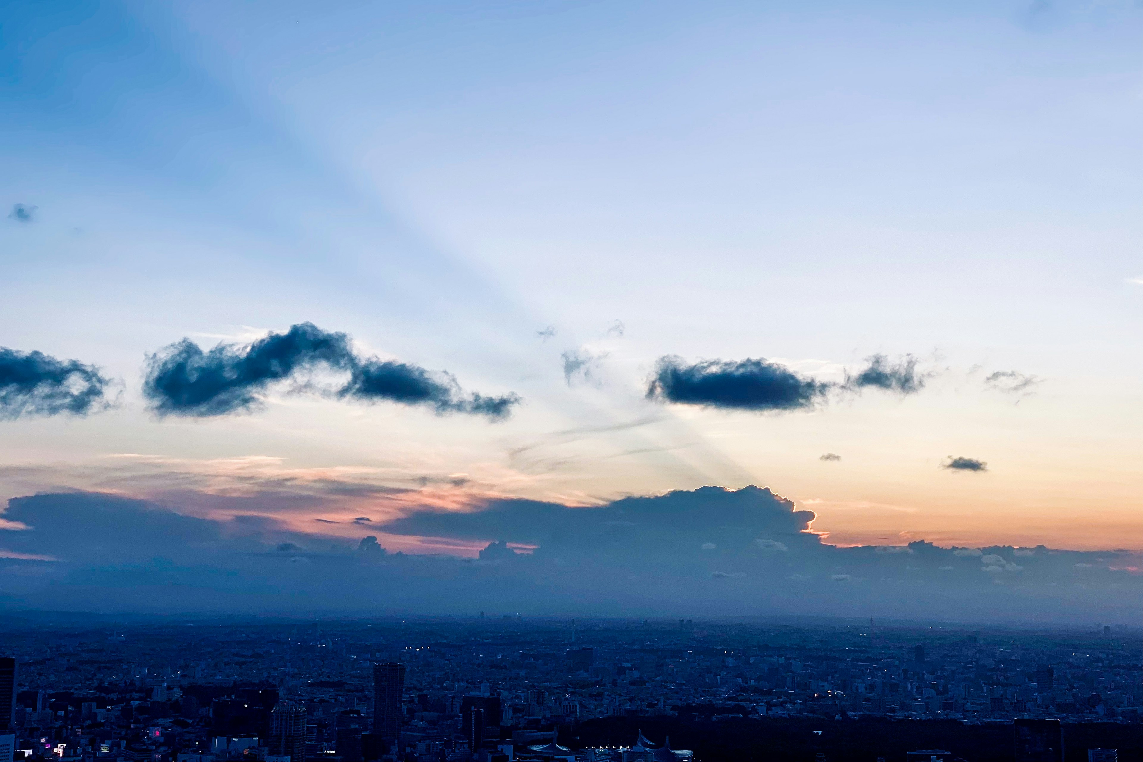 Sunset sky with clouds and distant cityscape