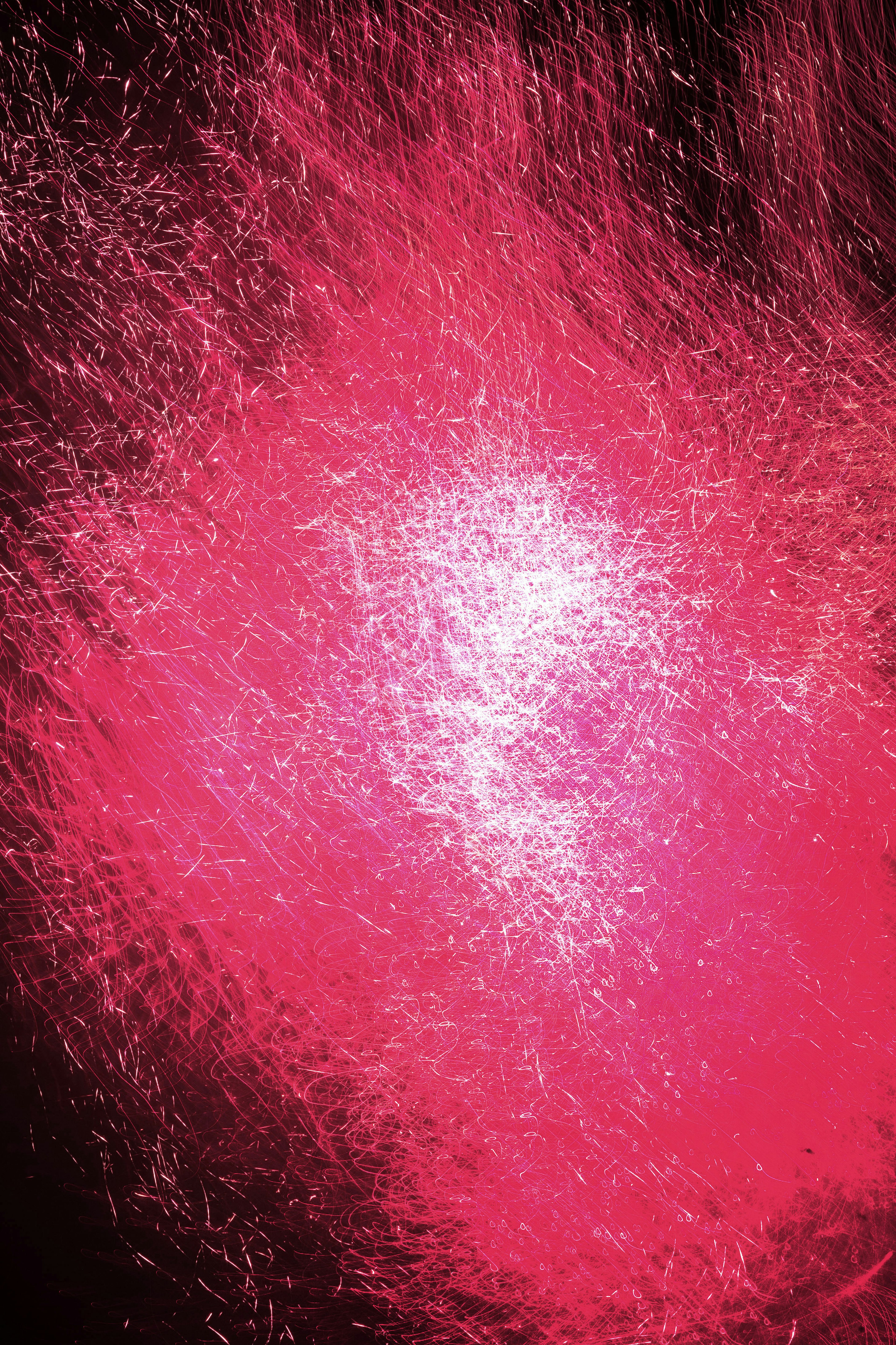 Vibrant pink sparkles radiating against a dark background