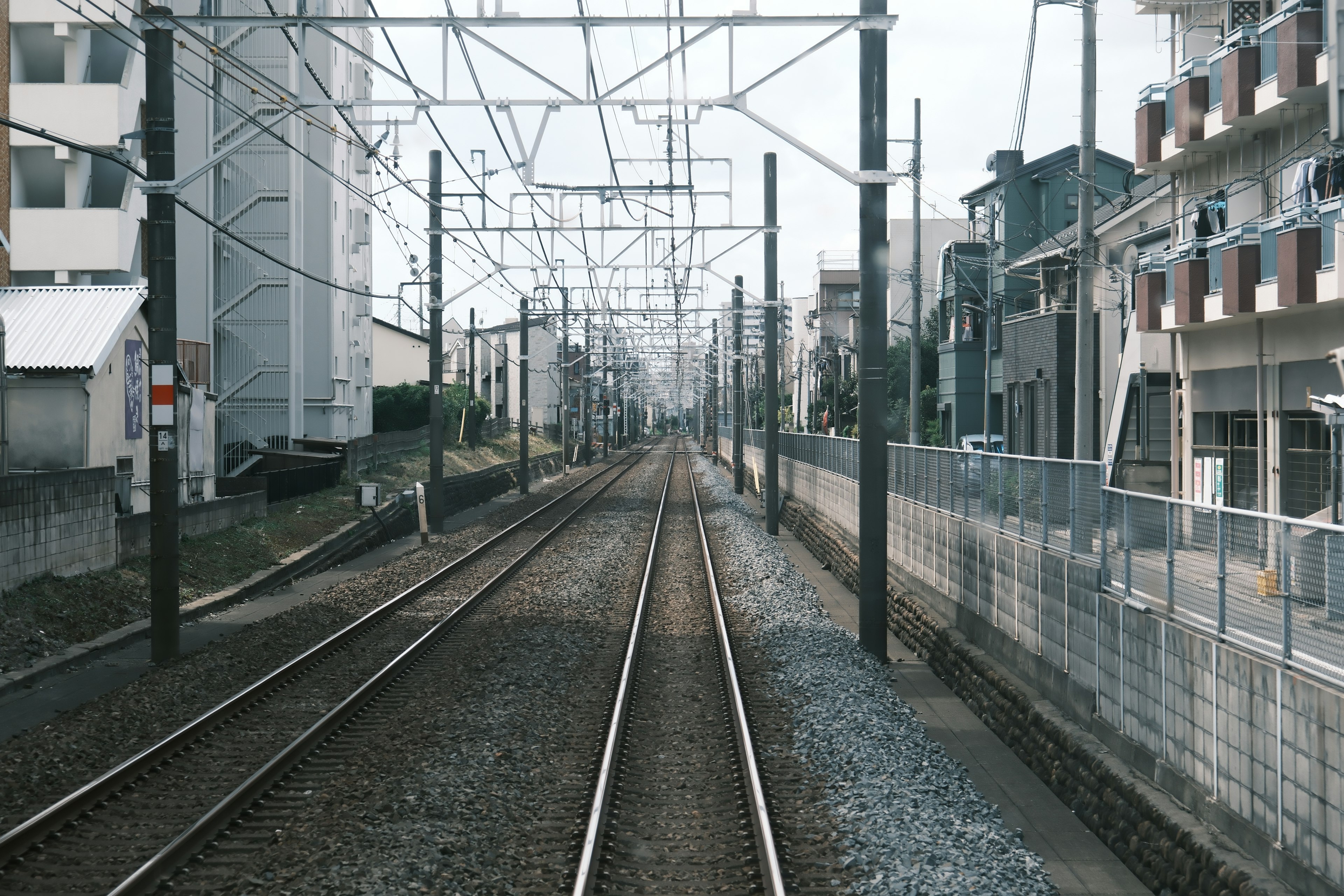 ภูมิทัศน์เมืองที่มีรางรถไฟและสายไฟเหนือศีรษะ