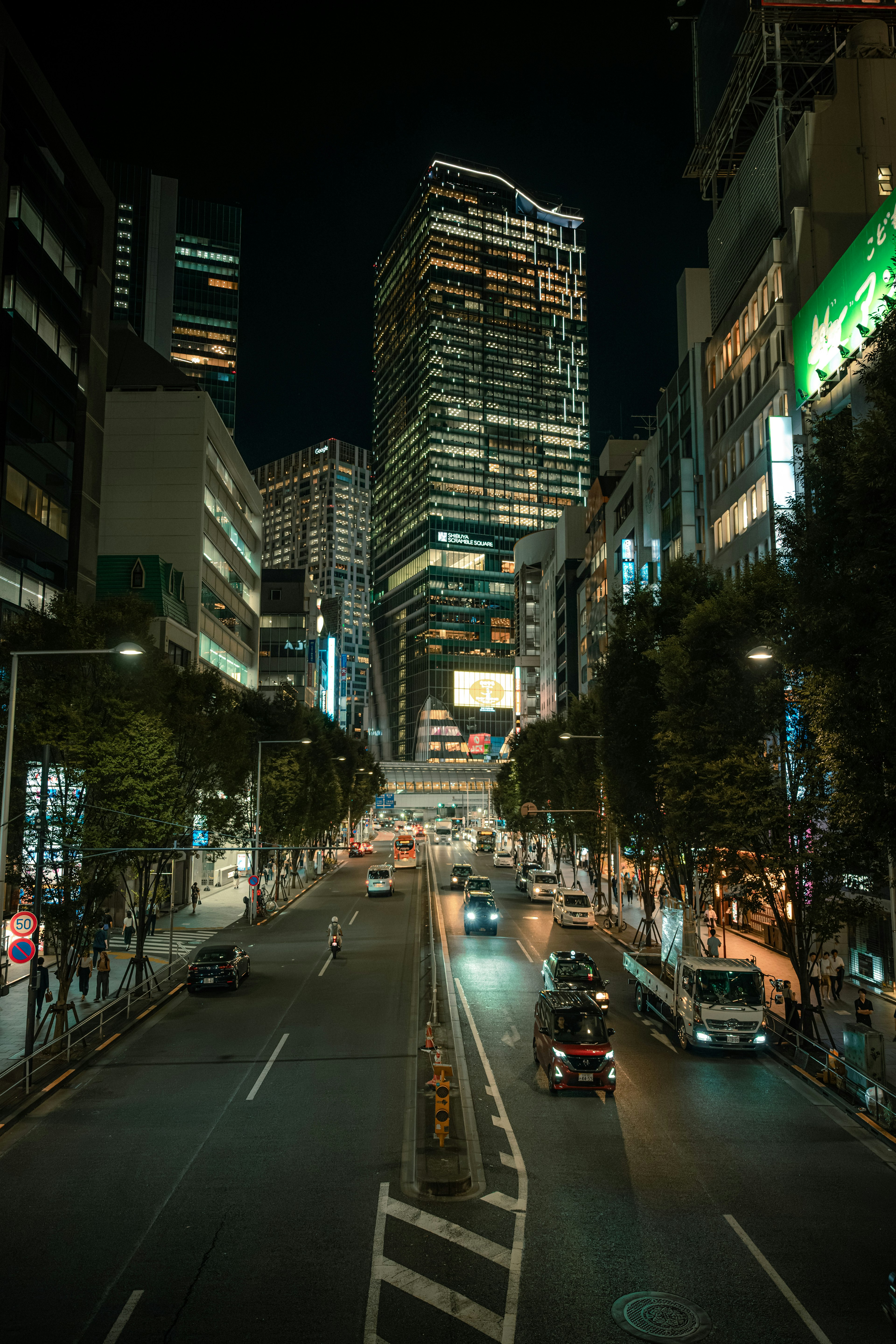 夜の都市風景 高層ビルが立ち並ぶ通り 車両の往来