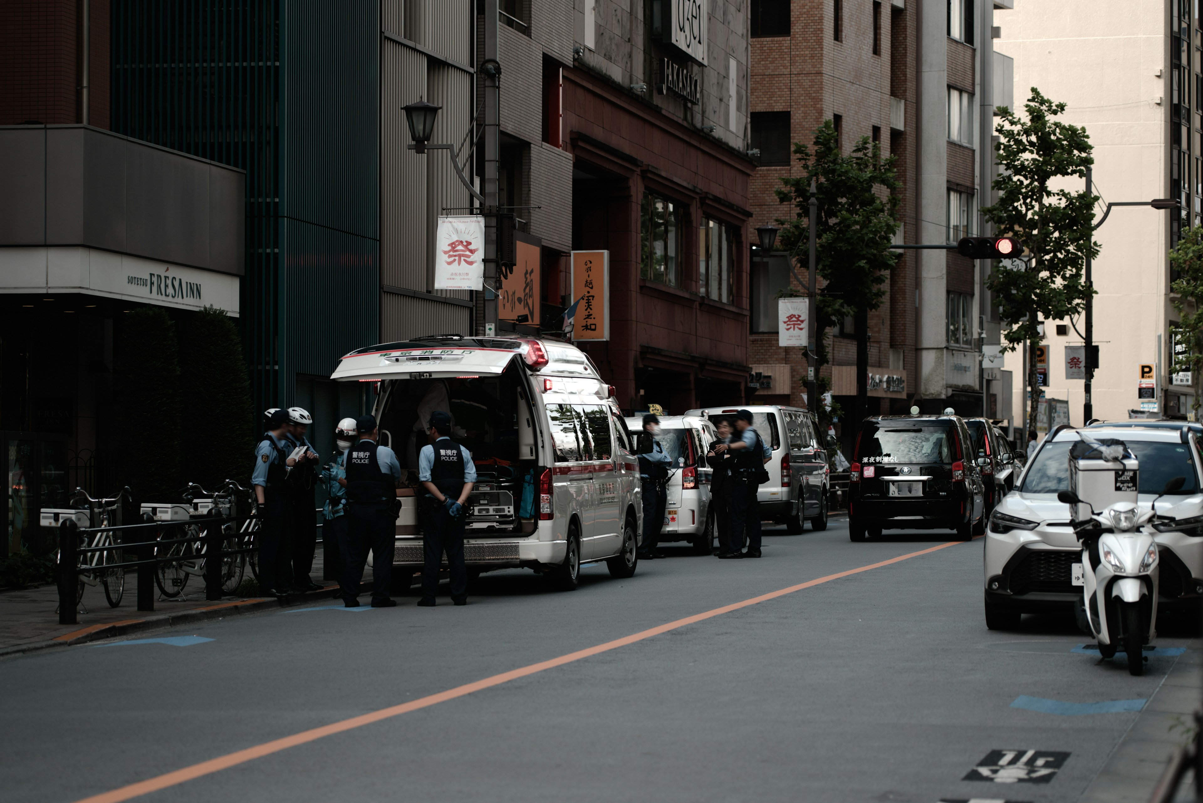 Emergency vehicle and police officers gathered on a city street