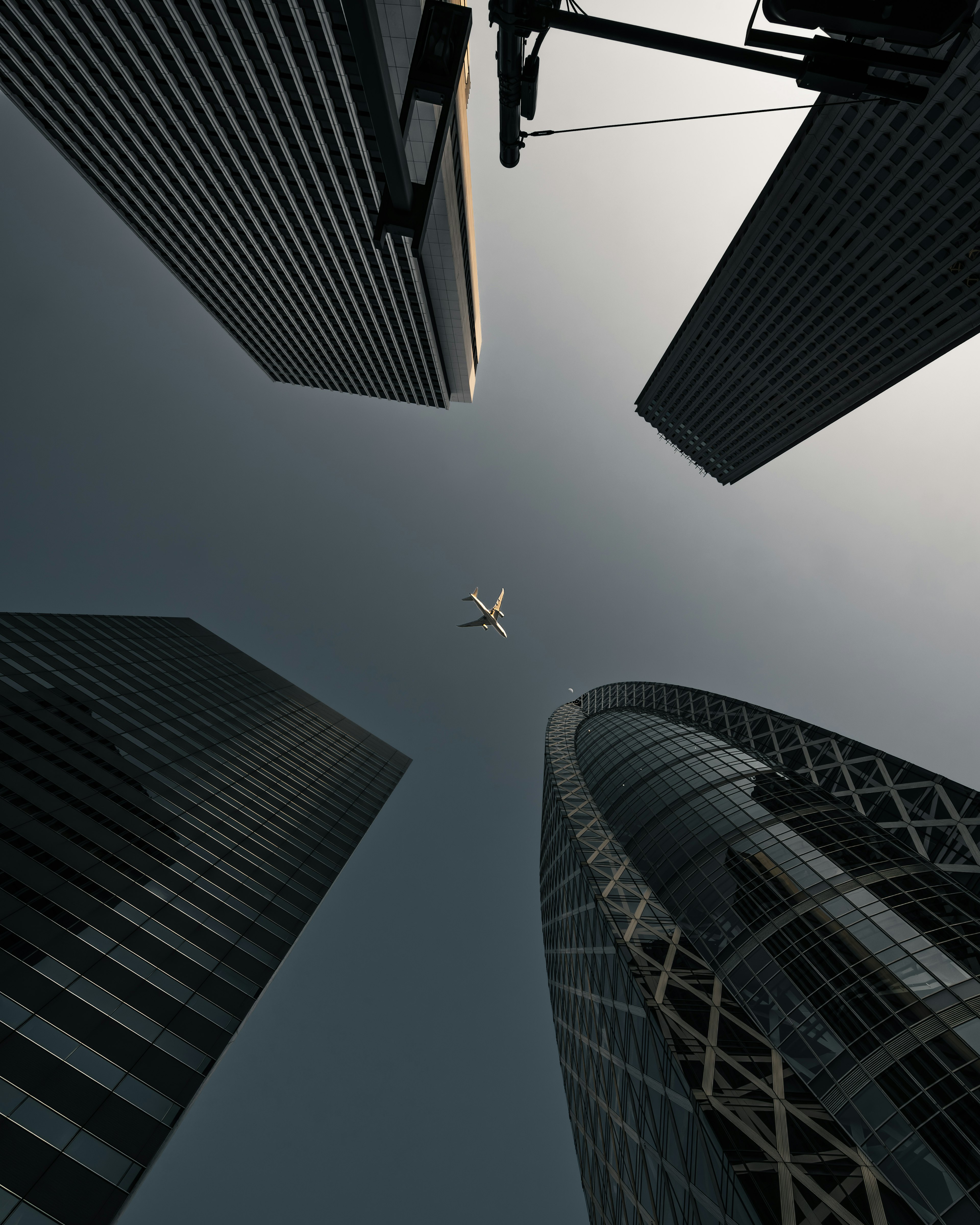 Aerial view of an airplane flying between tall buildings