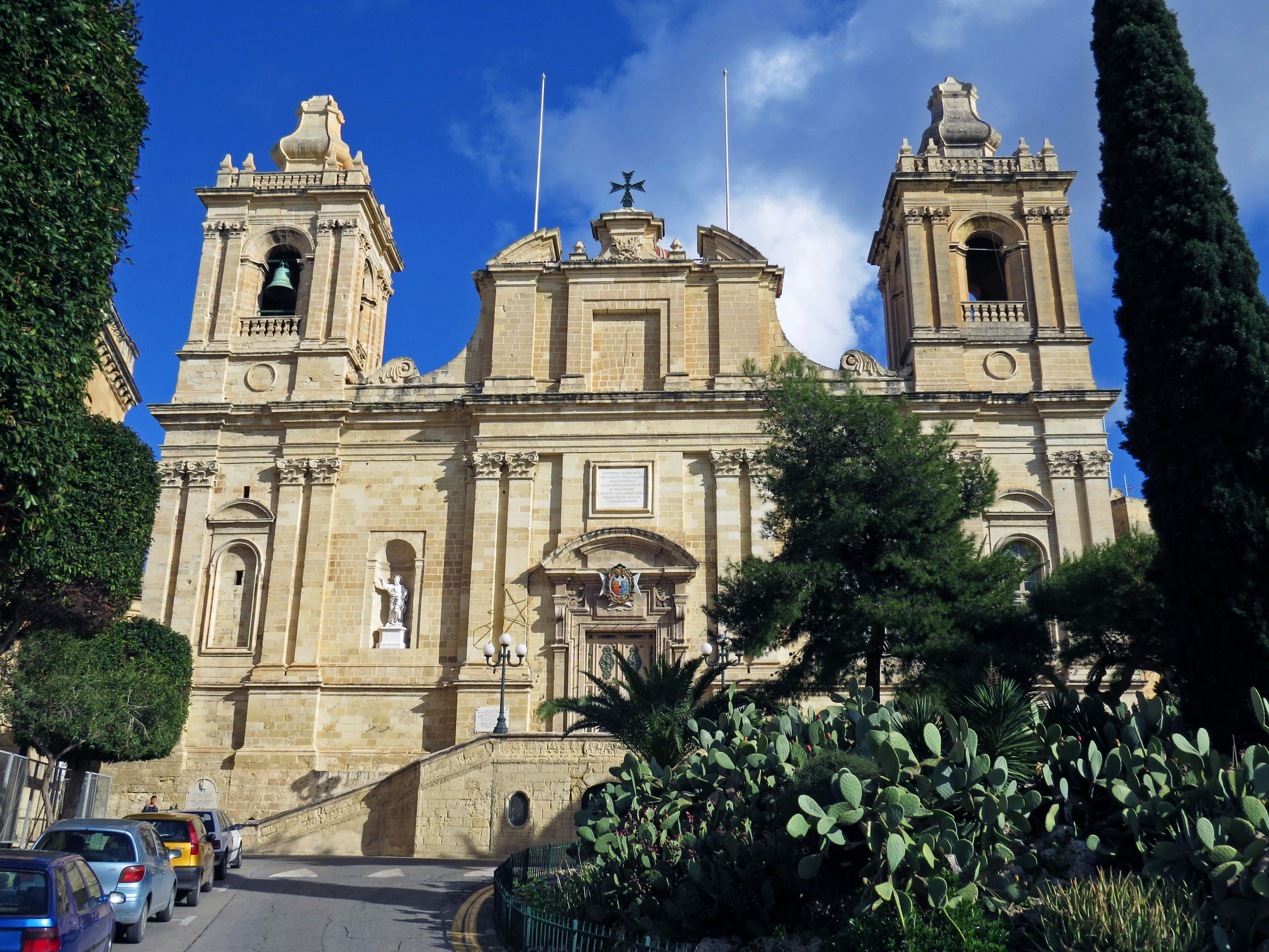 Tampilan luar Katedral St John di Valletta dengan menara tinggi dan ukiran rumit