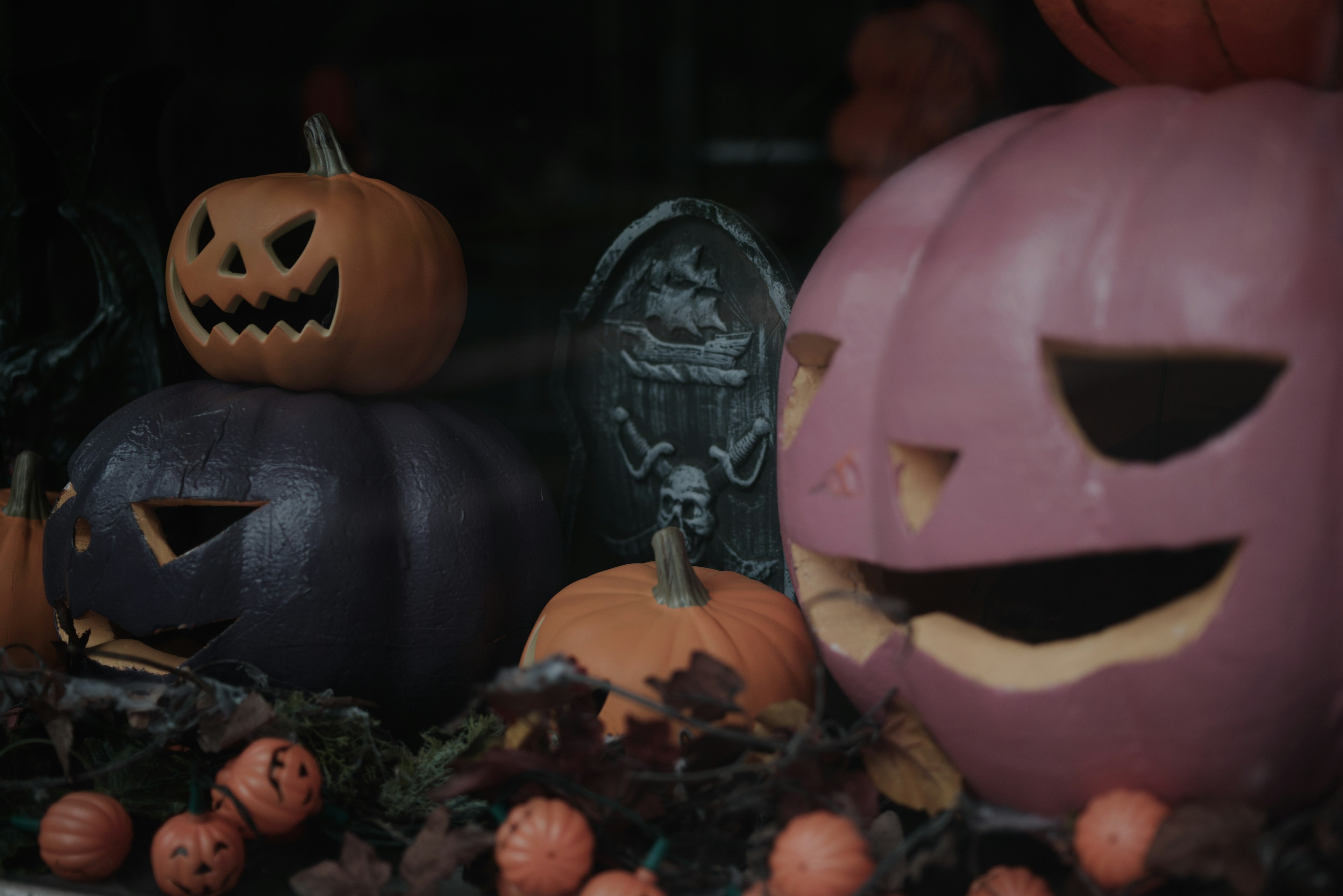 A scene featuring Halloween pumpkins with carved faces including a purple pumpkin and an orange pumpkin