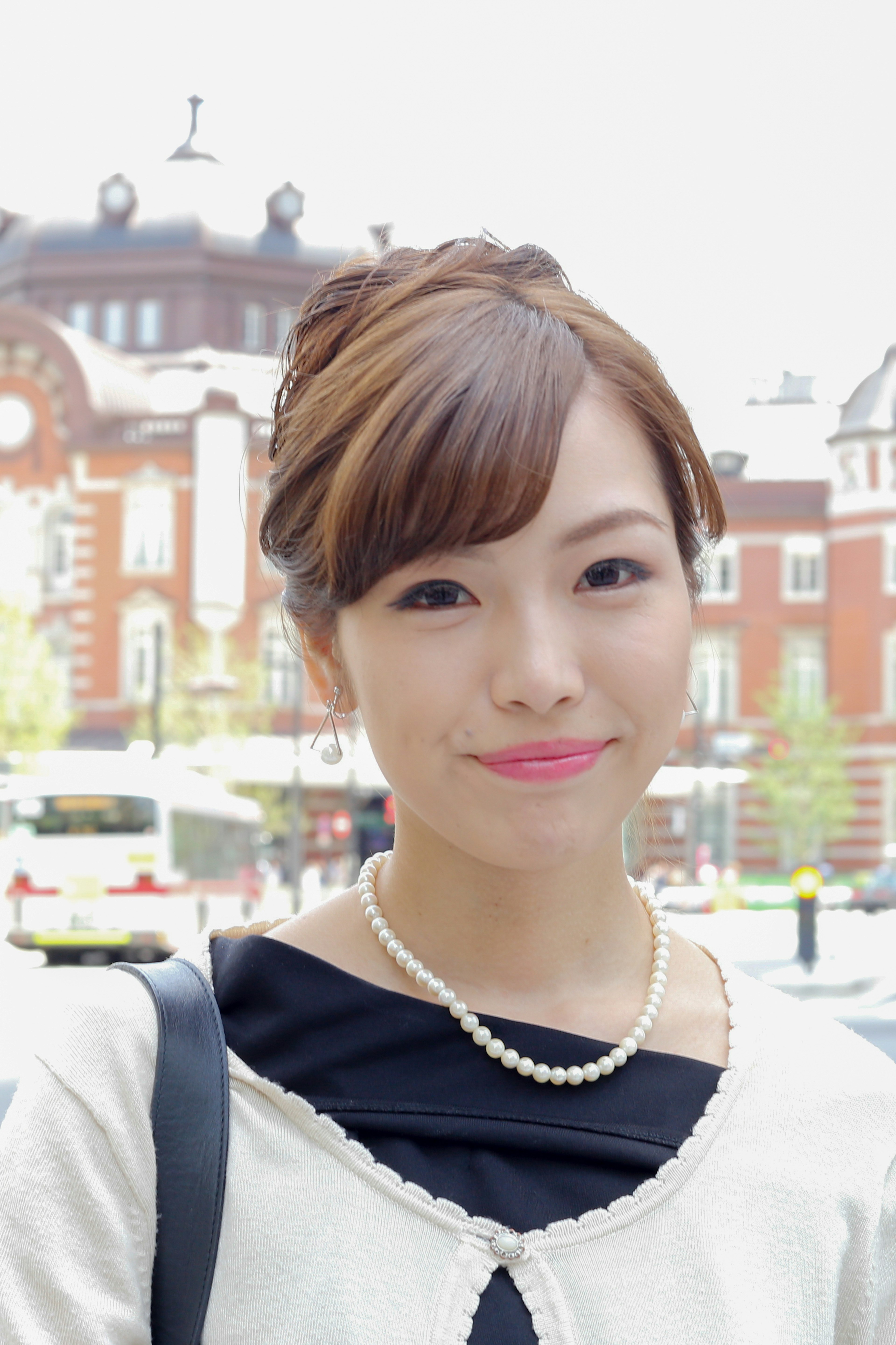 Young woman smiling in front of an urban background