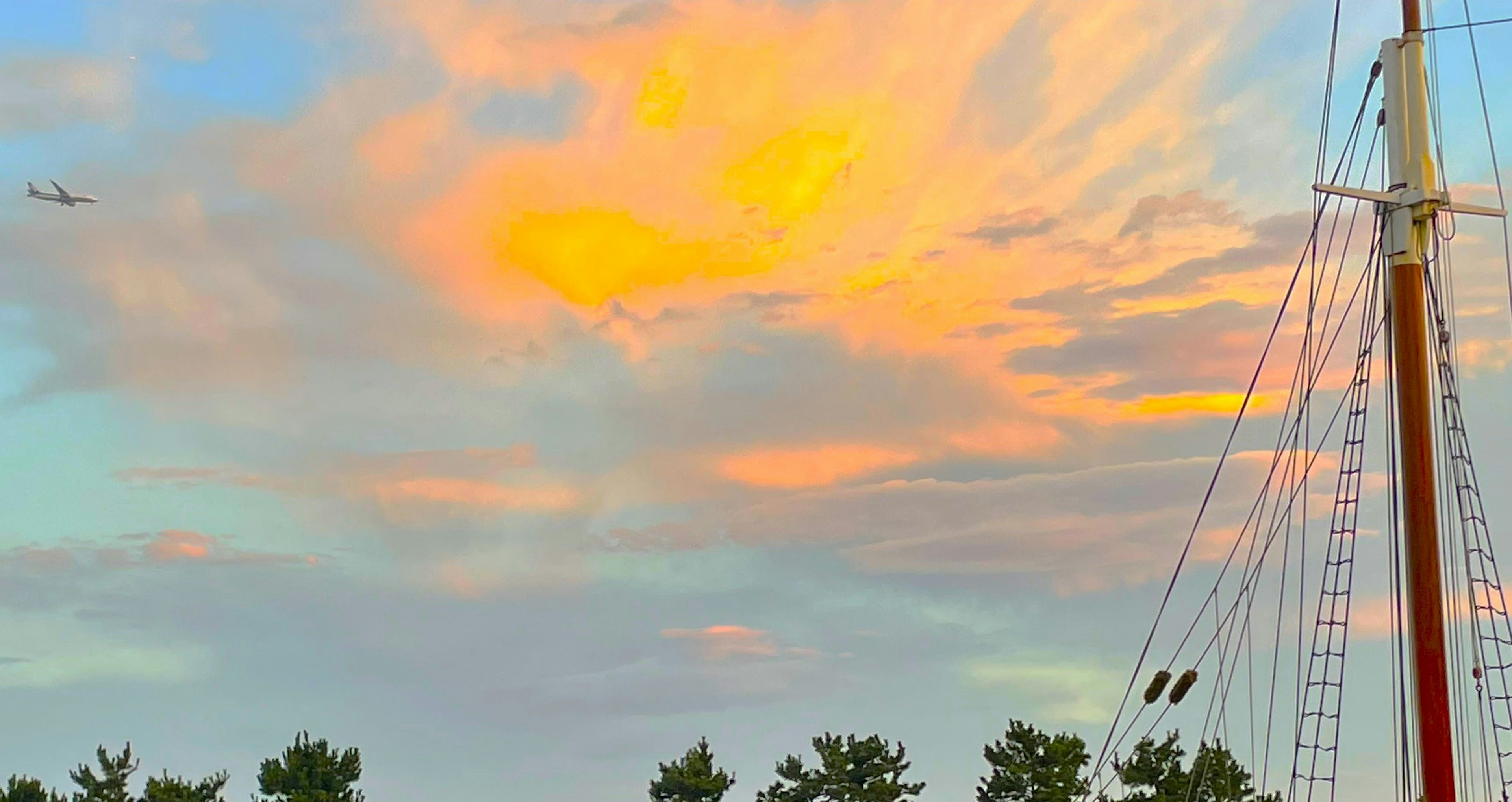 夕焼けの空と帆船のマストが映える景色