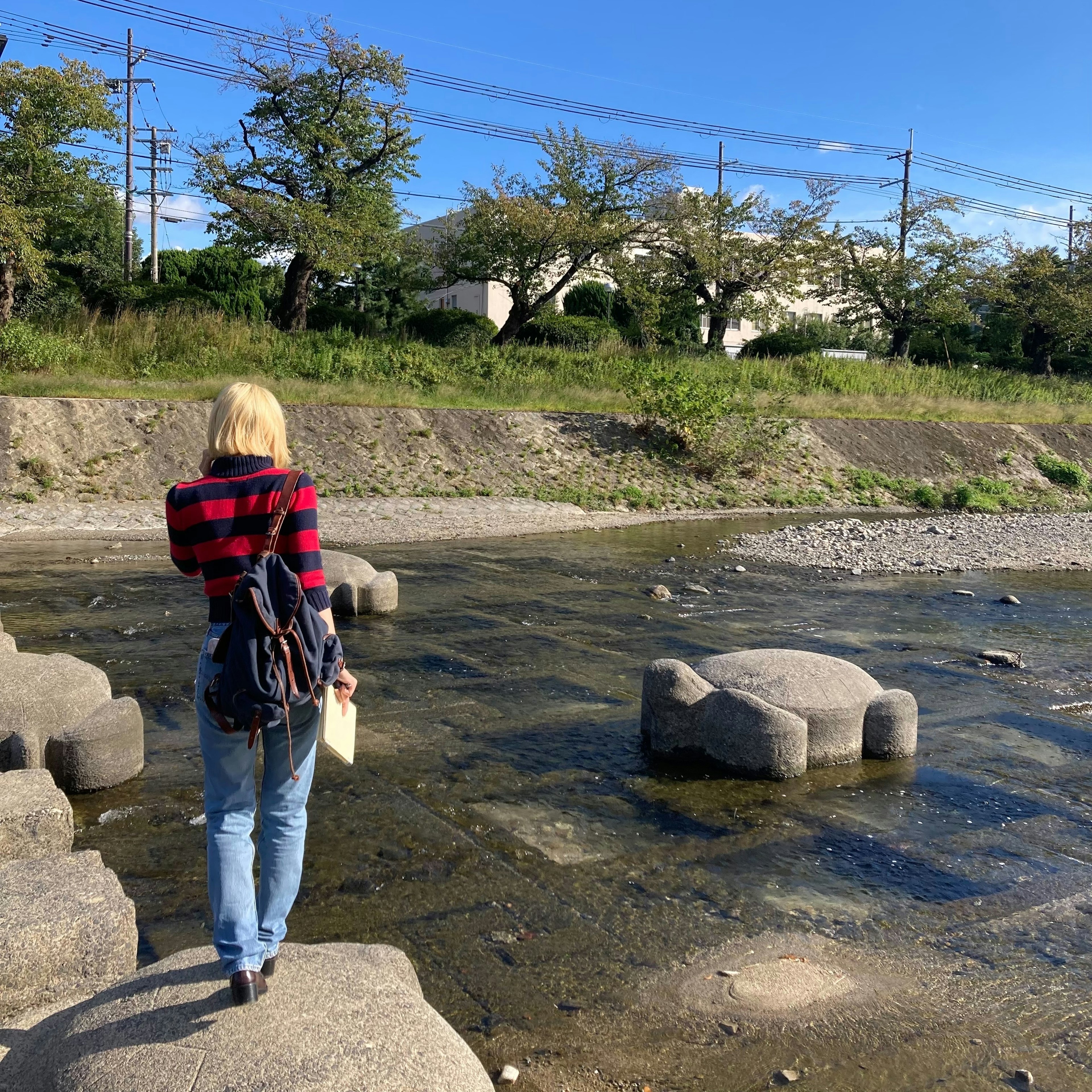 Una mujer caminando sobre piedras en un río