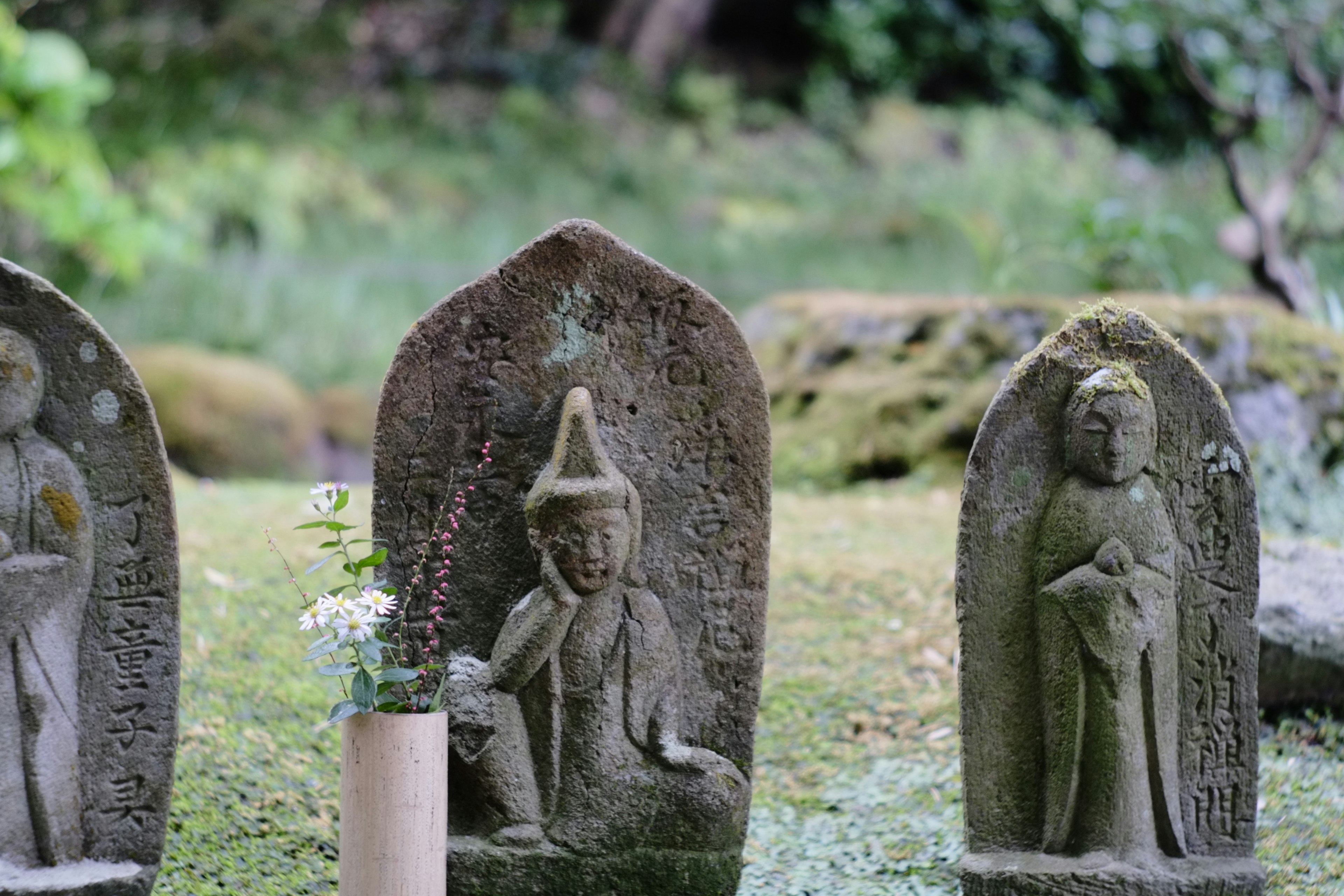 Escena de jardín serena con estatuas de piedra y fondo verde