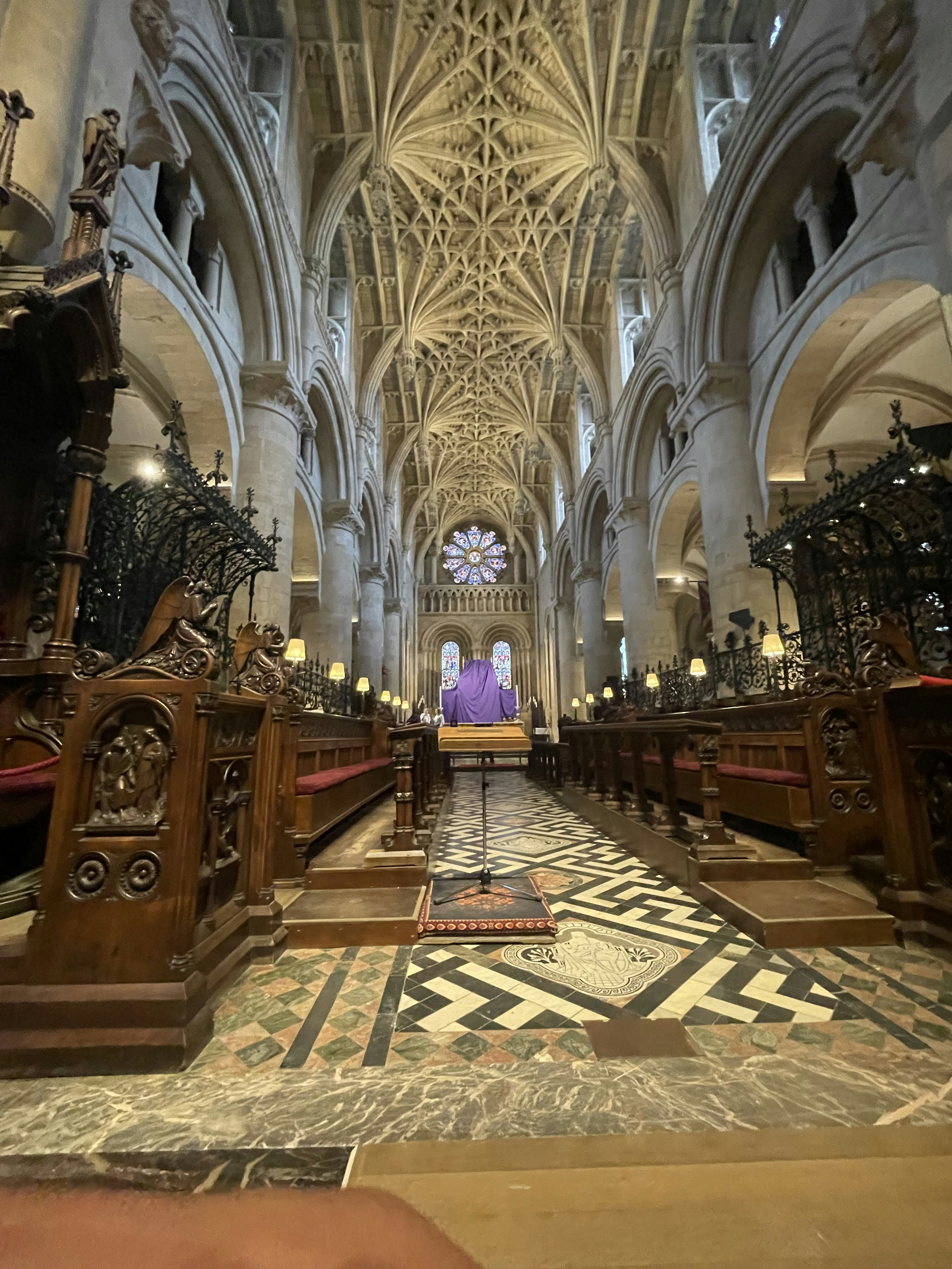 Interno maestoso di una chiesa con design del soffitto intricato panche in legno e una persona in piedi al centro