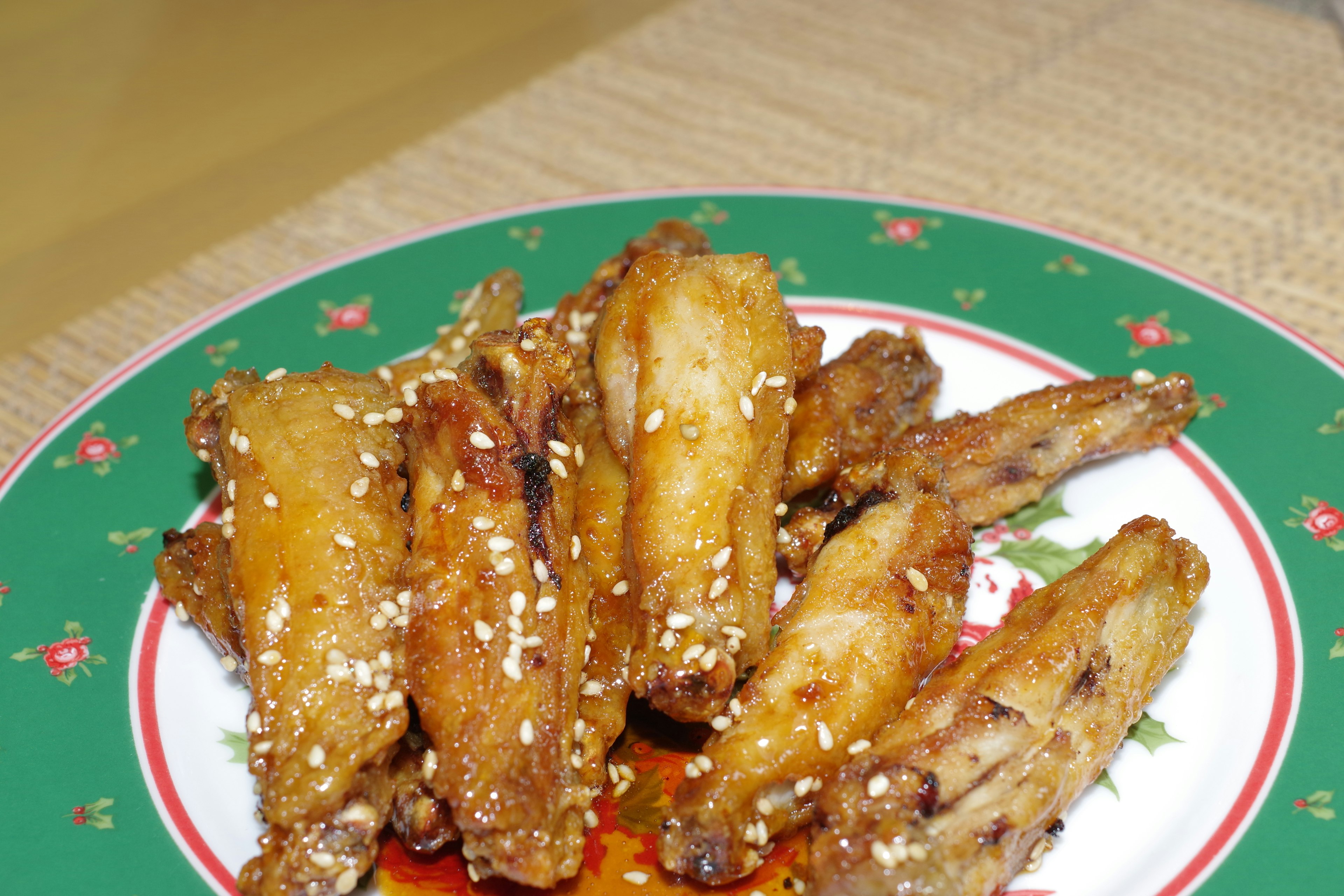 Piring sayap ayam goreng yang dihiasi dengan biji wijen