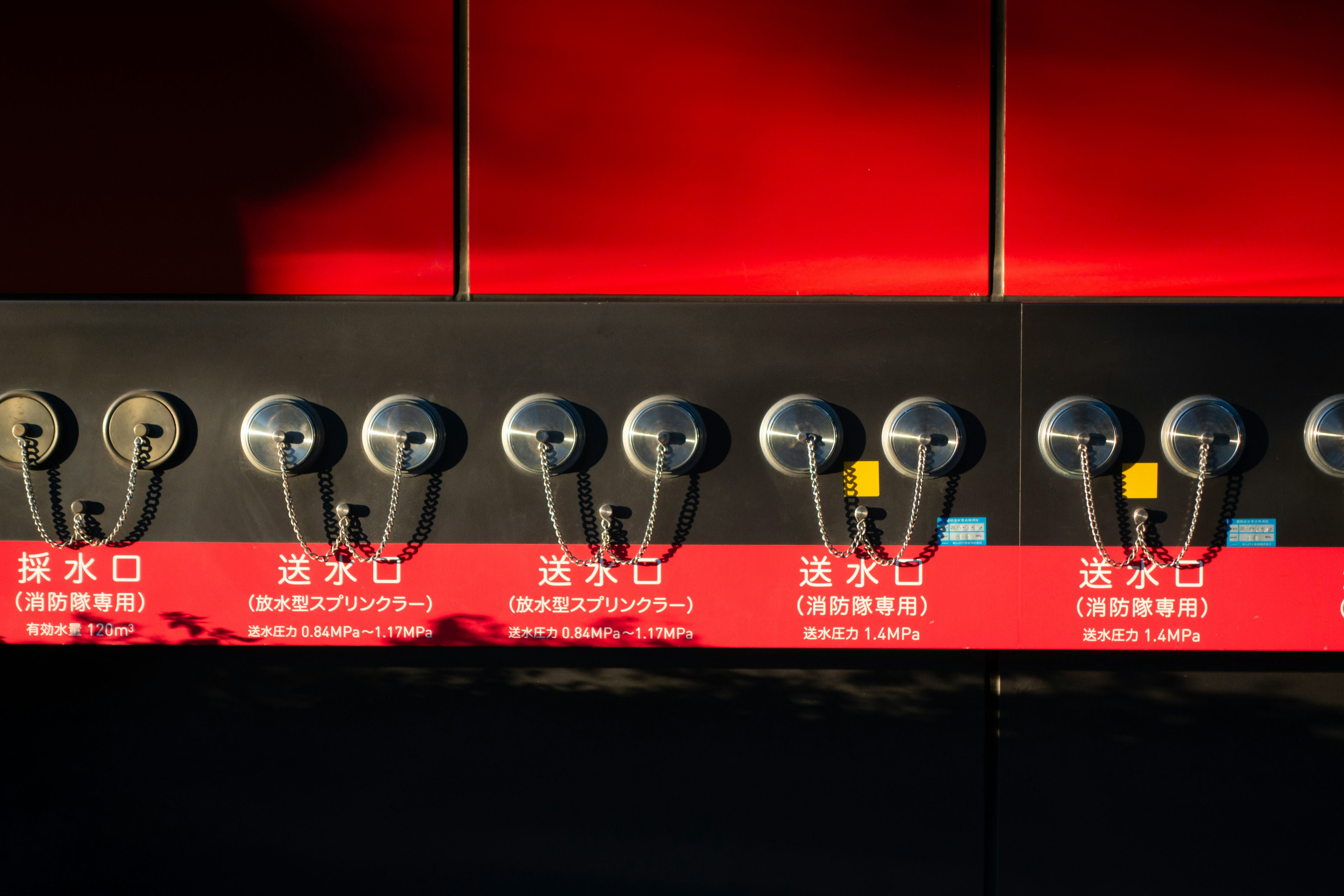 Faucets lined up against a red background with labels