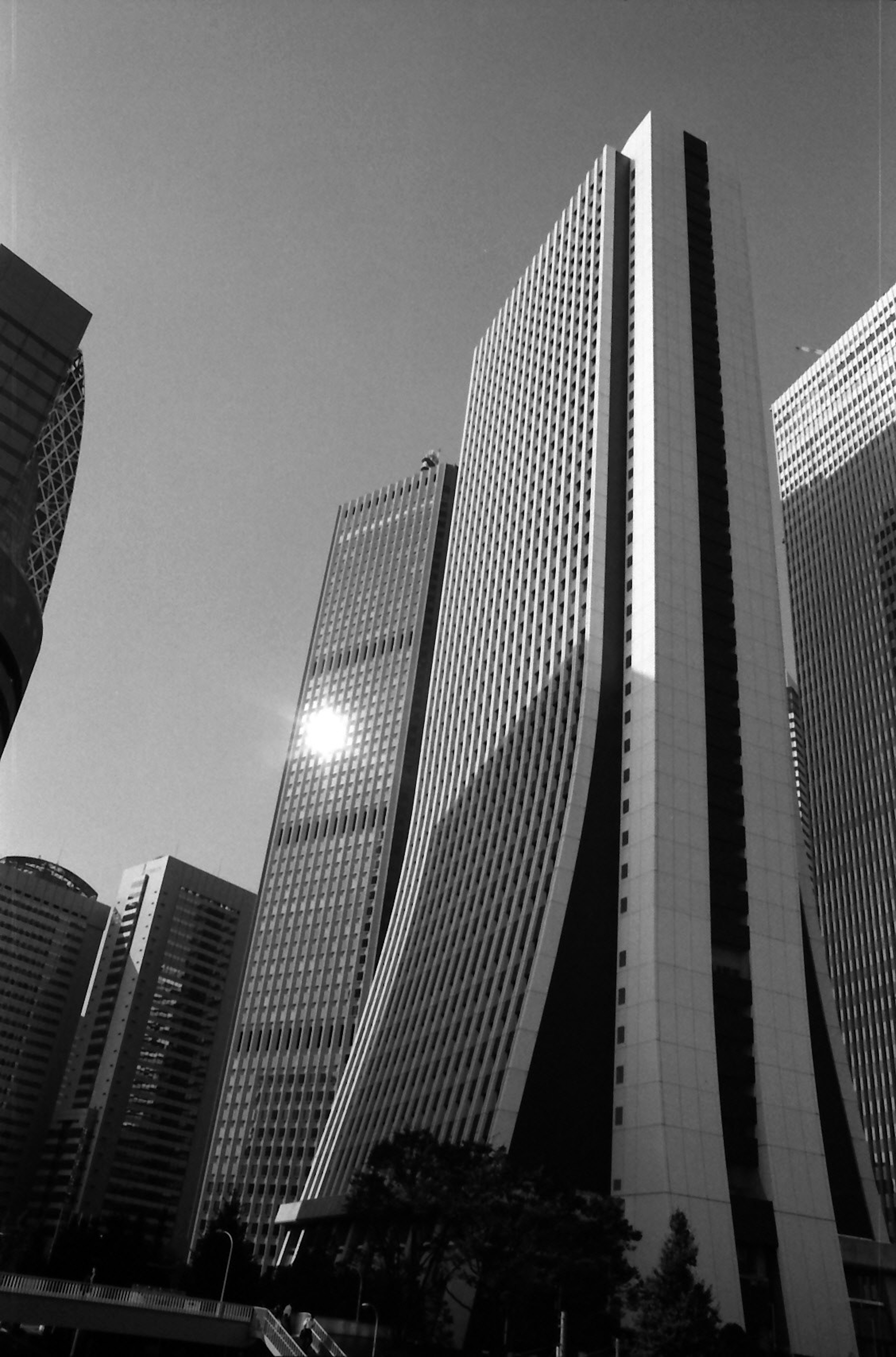 Moderne Wolkenkratzer in einer Stadtlandschaft mit monochromen Tönen und Lichtreflexionen