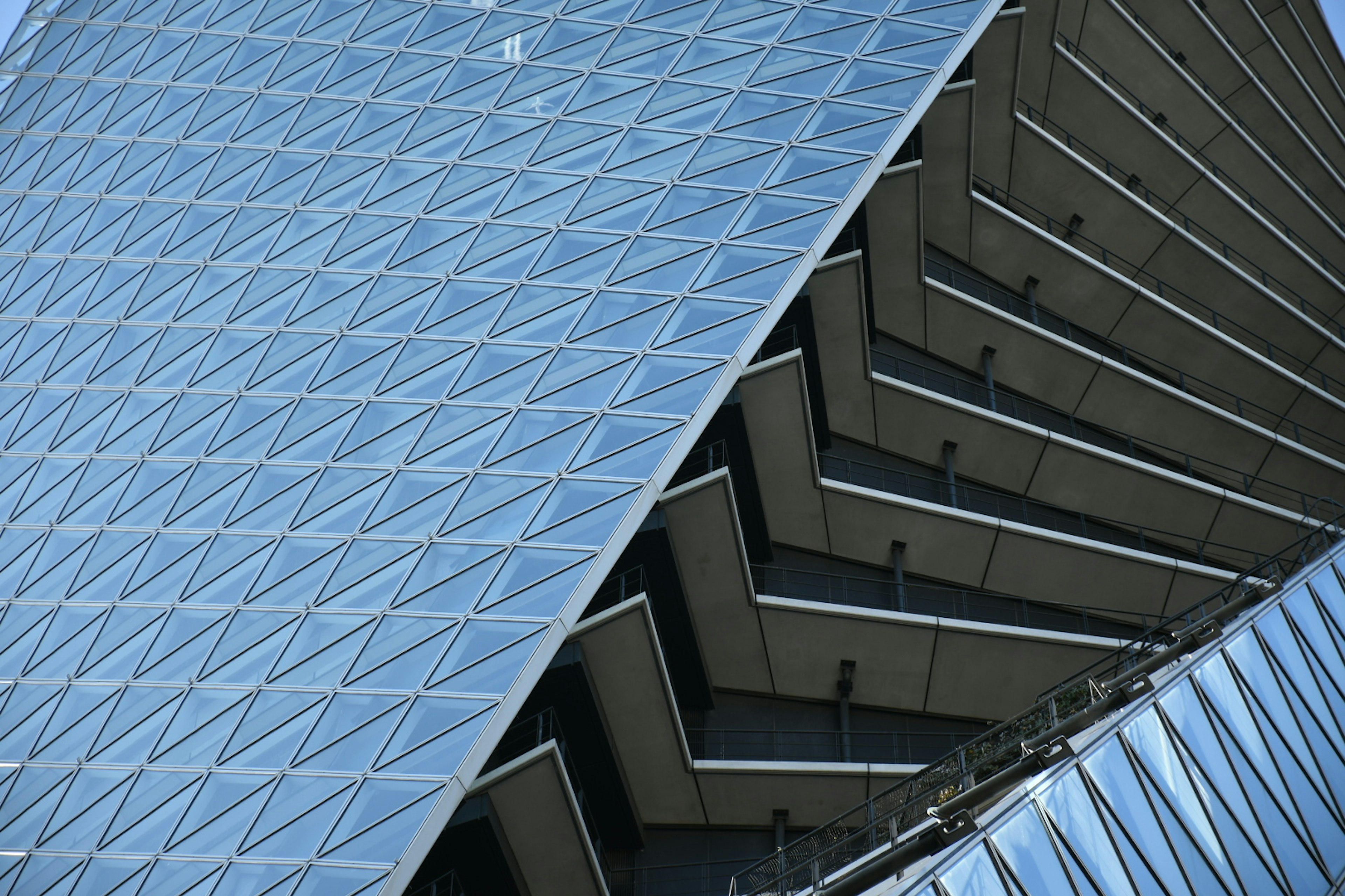 Architecture moderne avec une façade en verre diagonale et un design en escalier