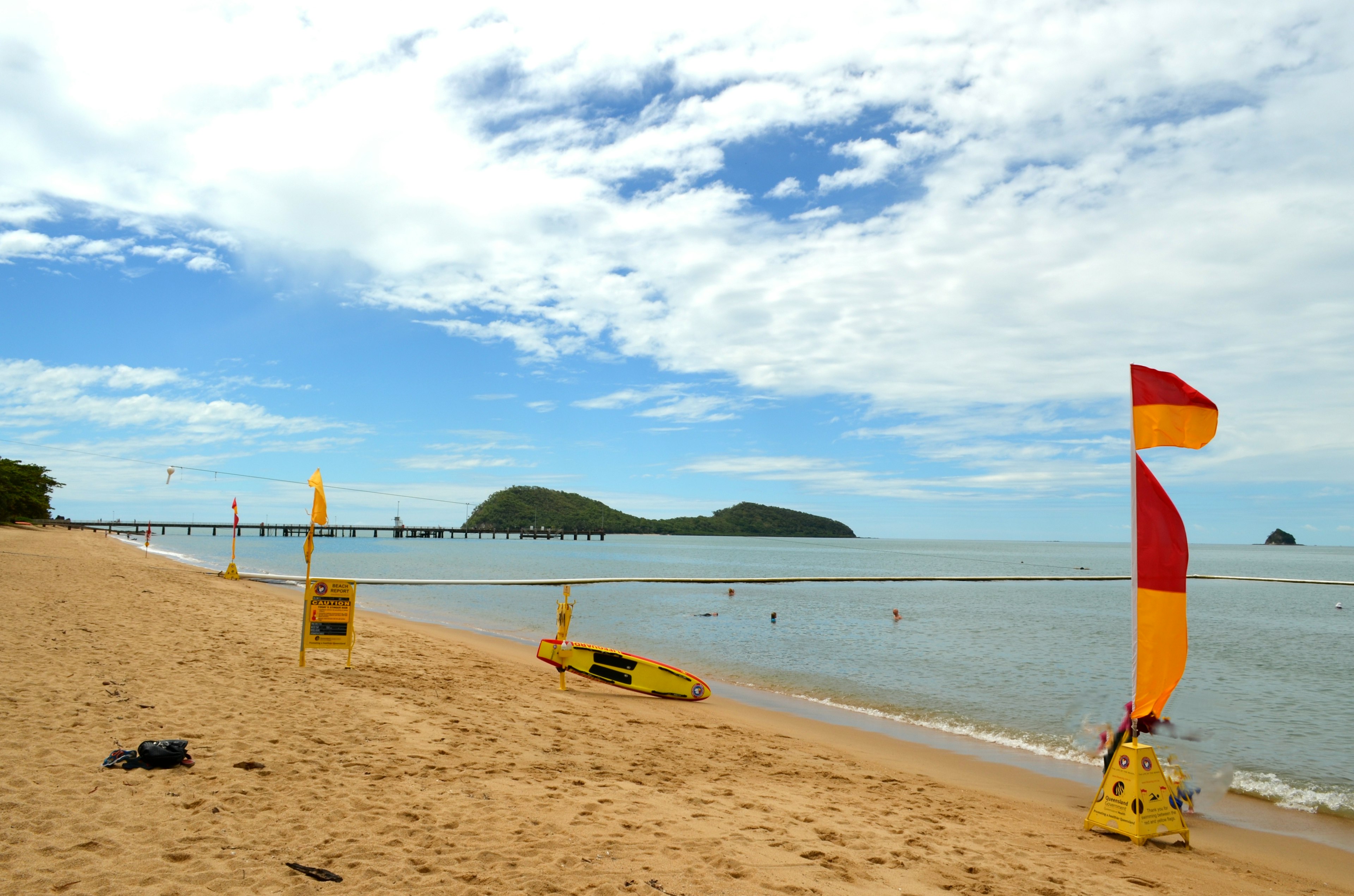 ทิวทัศน์ชายหาดที่มีธงและป้ายความปลอดภัย