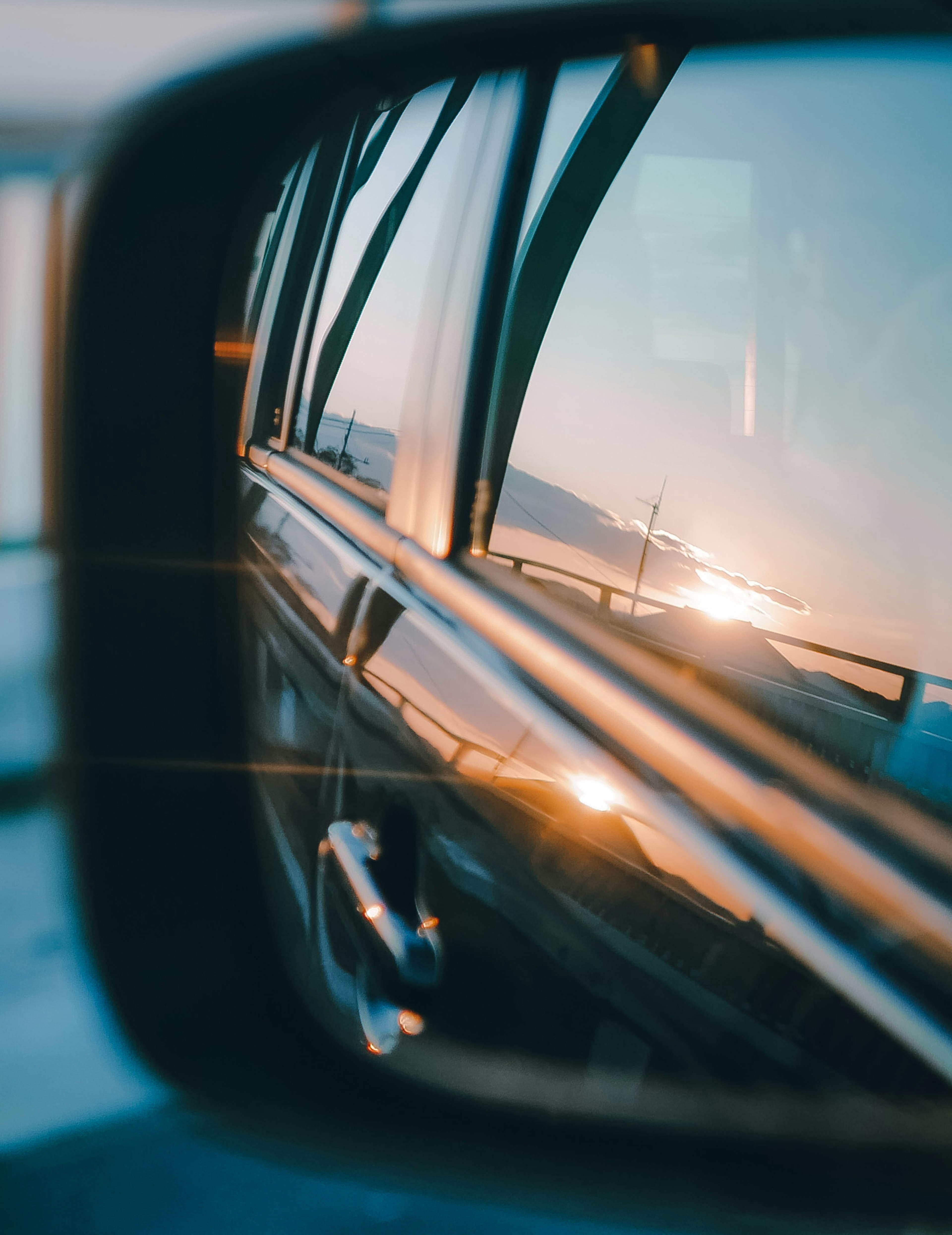 Réflexion du coucher de soleil et de l'océan dans un rétroviseur de voiture