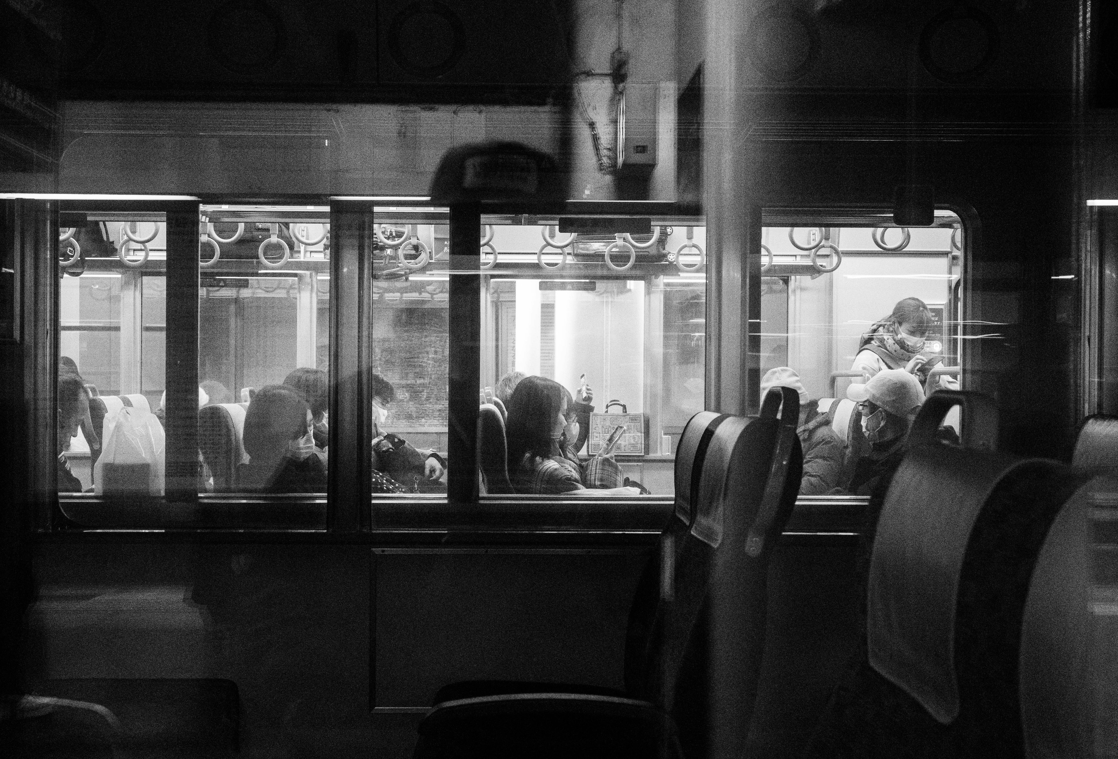 Black and white image of a train interior with people seated