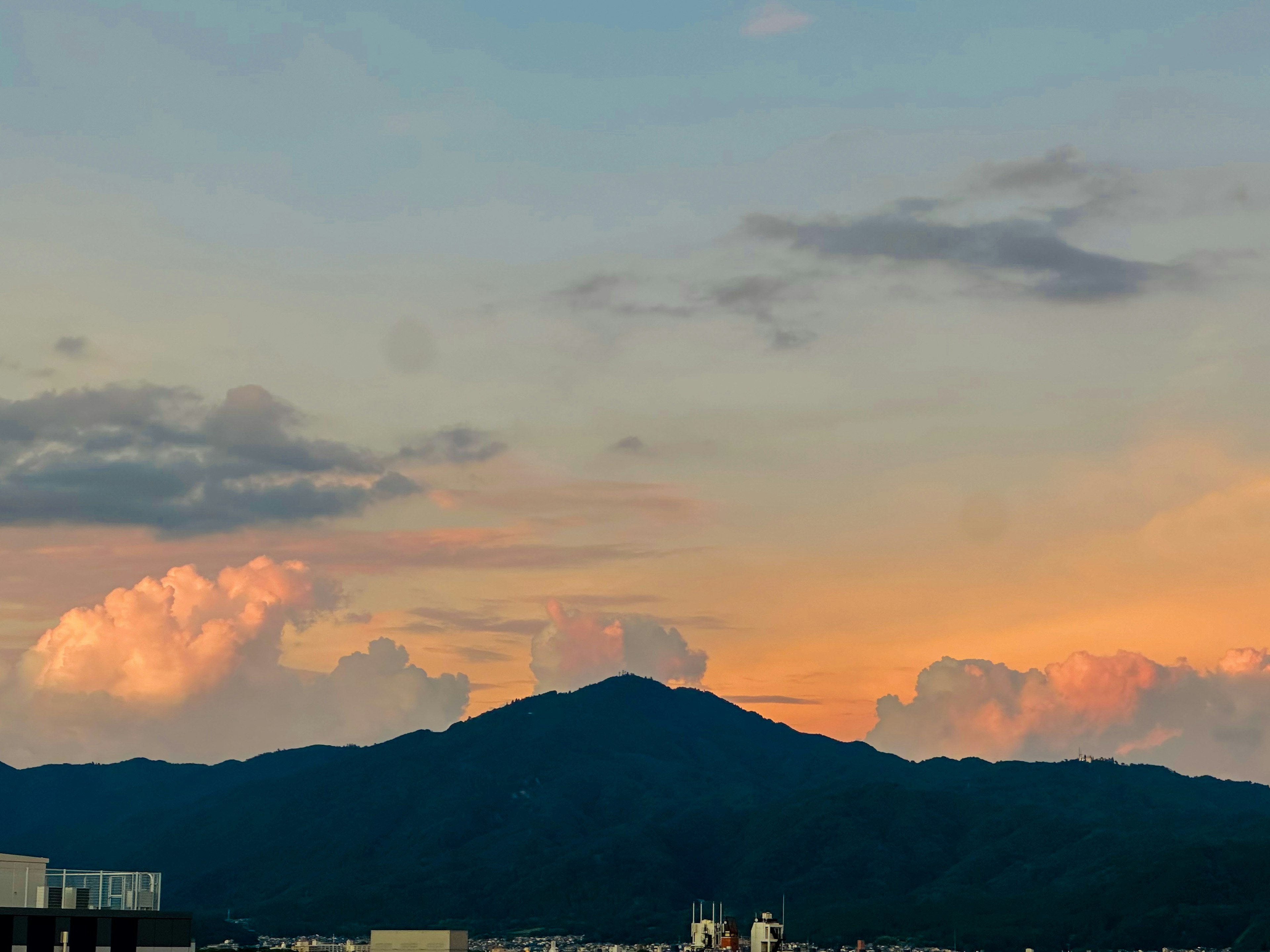 Vista panoramica di una montagna e nuvole illuminate dal tramonto