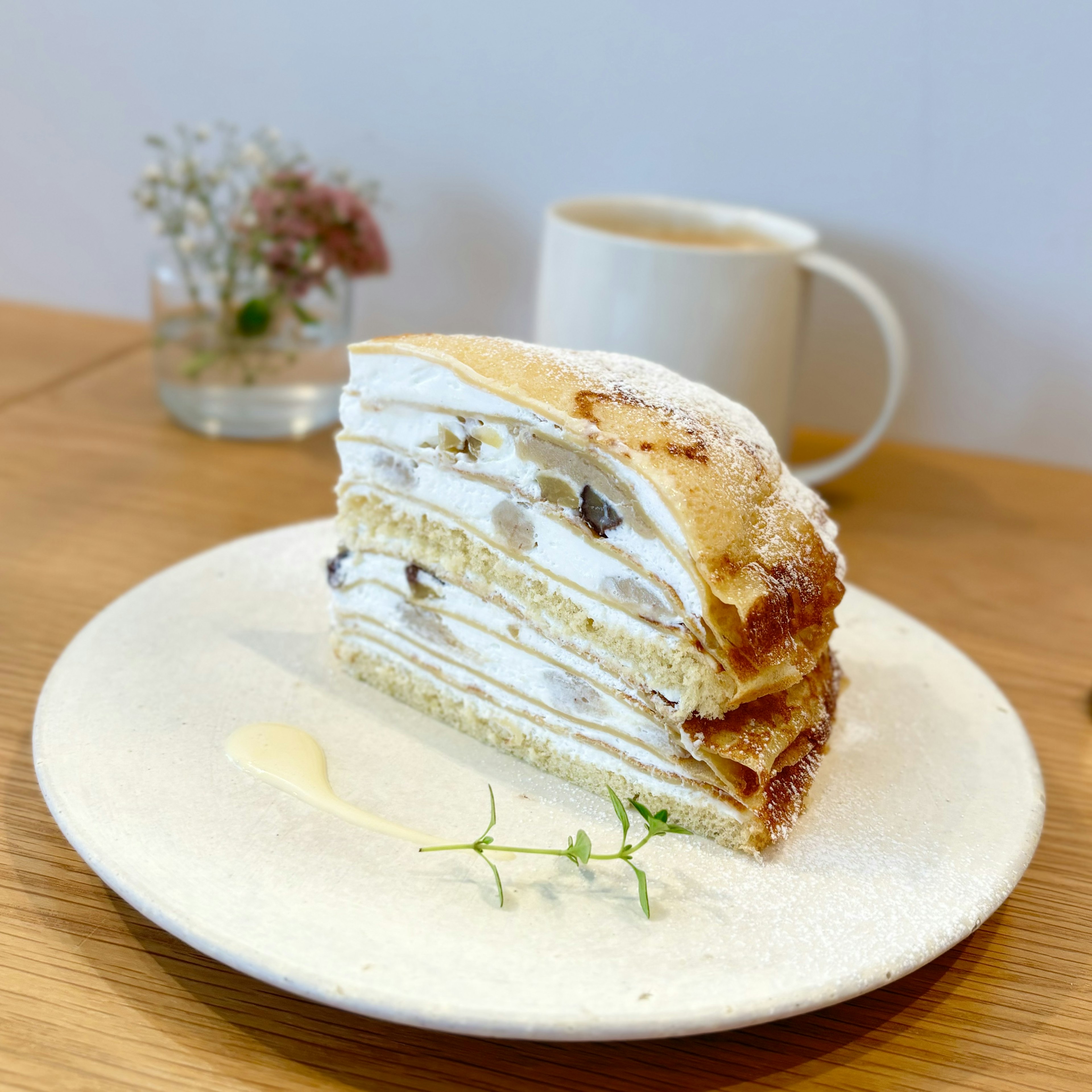 Layered cake with cream and nuts served on a plate with a drink