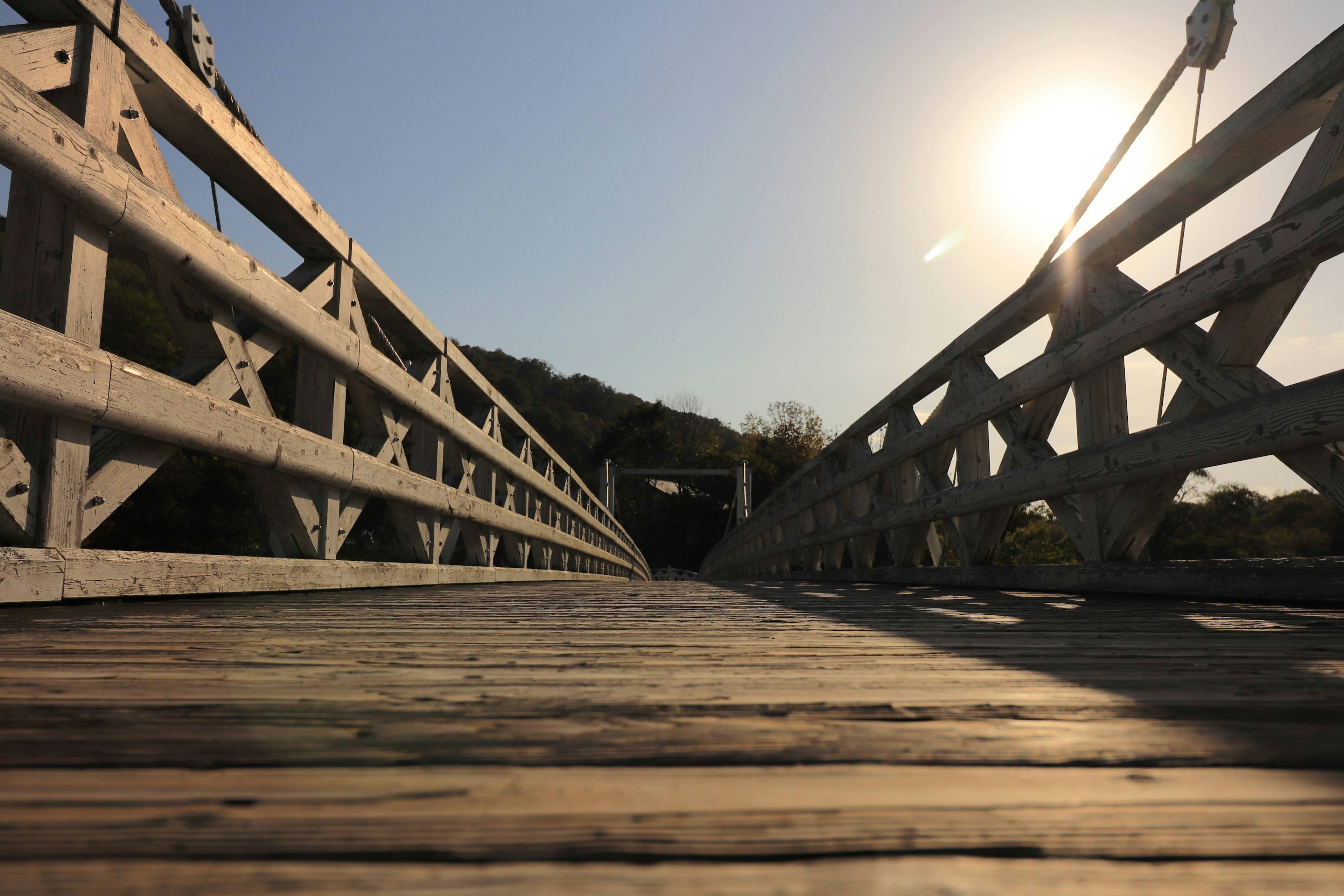 Holzbrücke aus niedriger Perspektive mit hellem Sonnenlicht