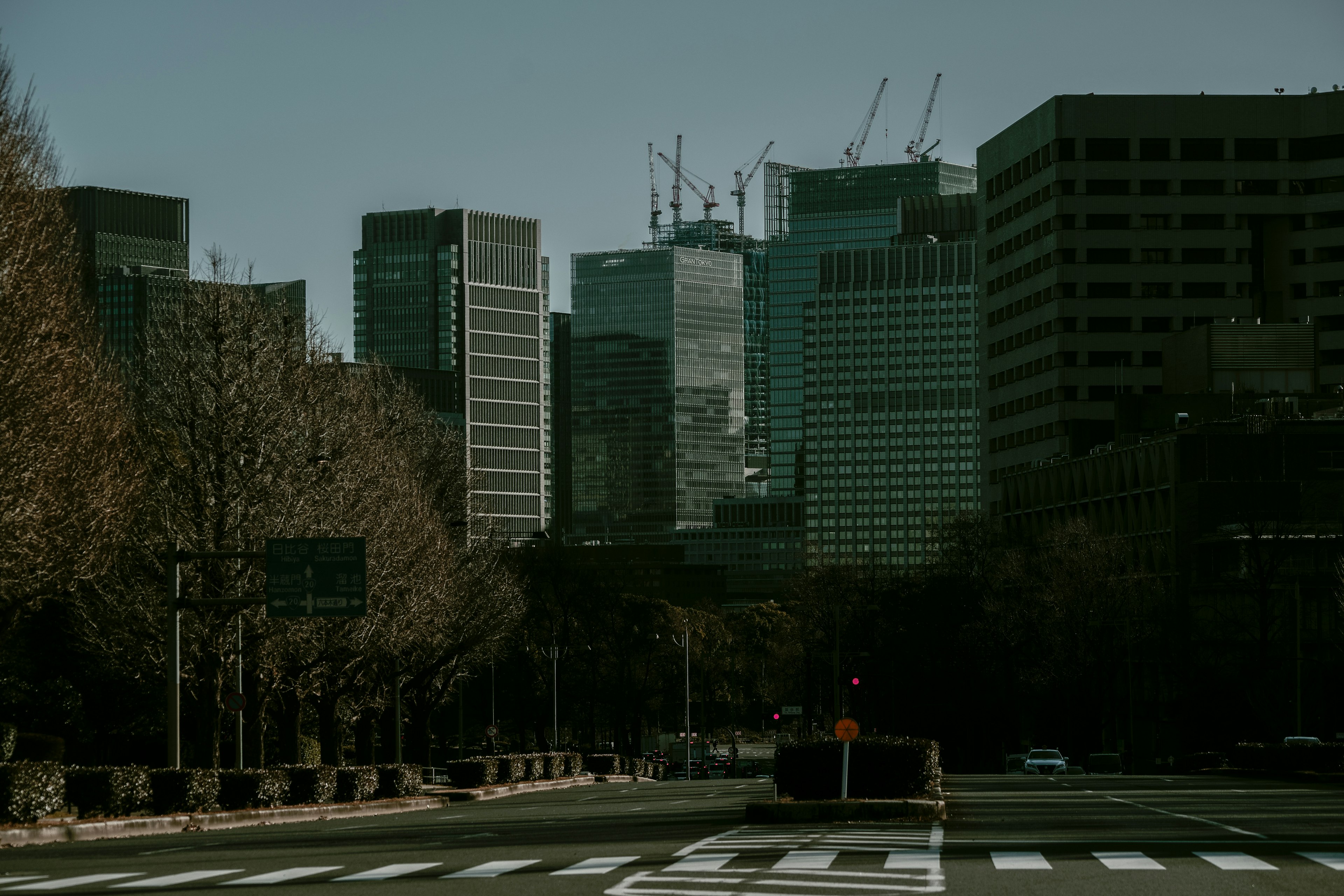 都市のビル群と工事中の建物を背景にした通りの風景