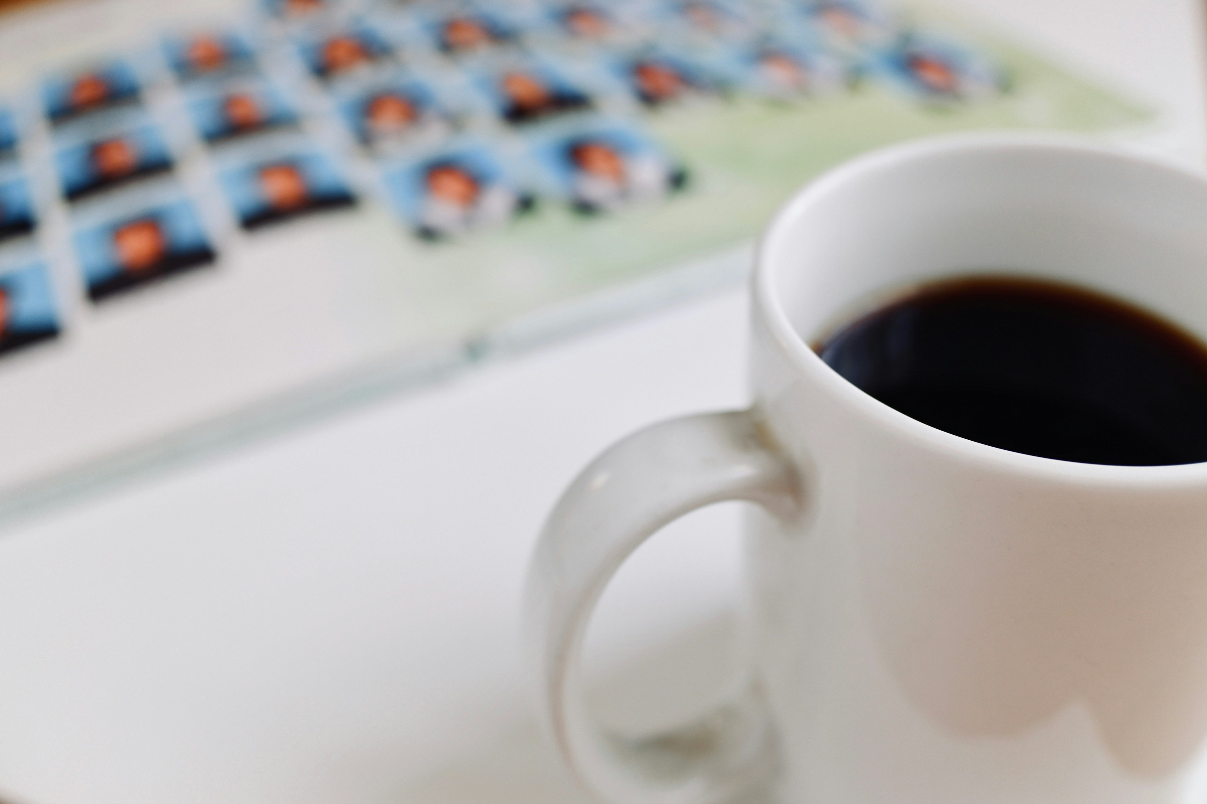 Una taza de café blanca con un fondo de múltiples fotos dispuestas