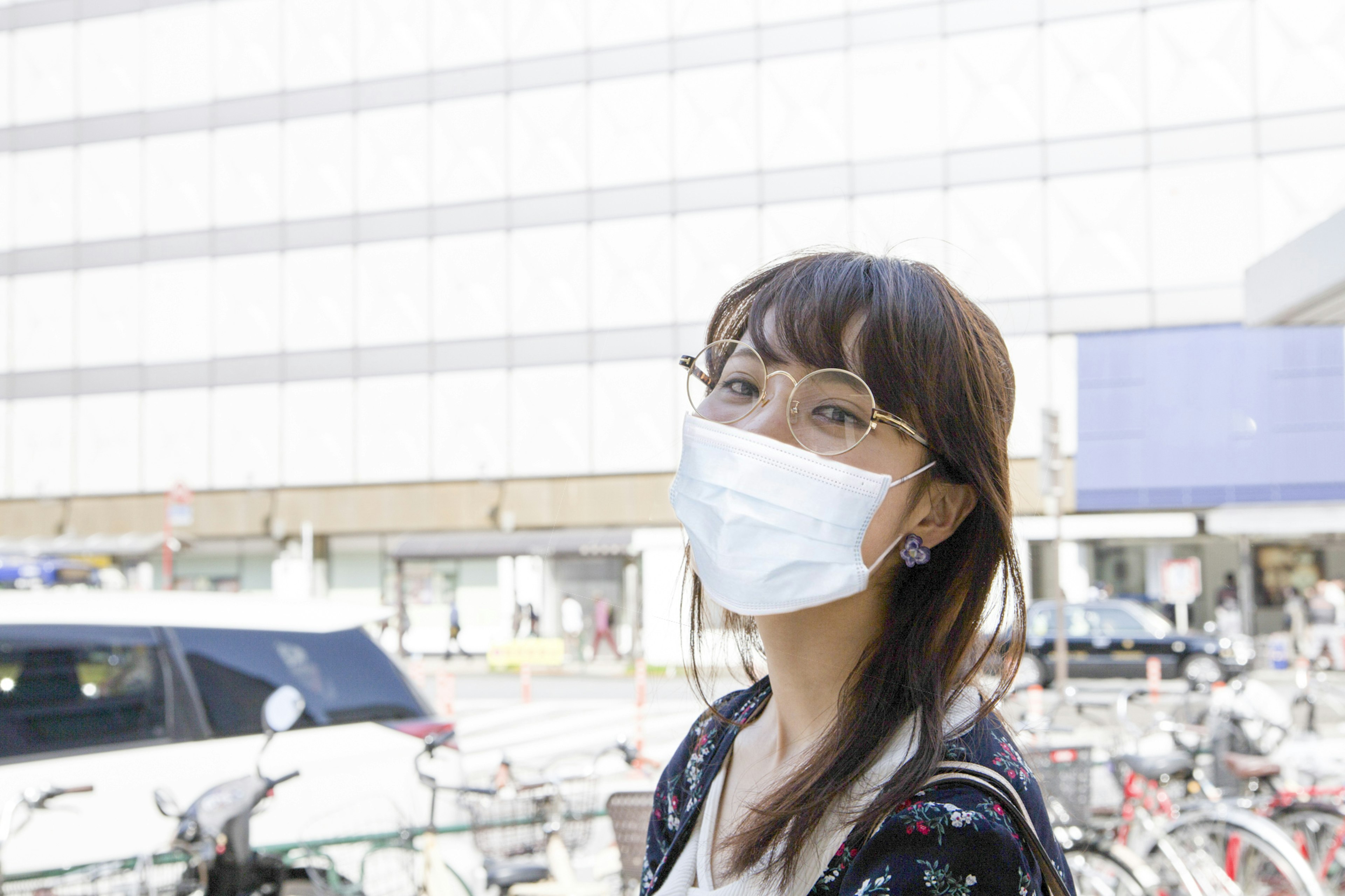 Una donna che indossa una maschera sorridendo per strada