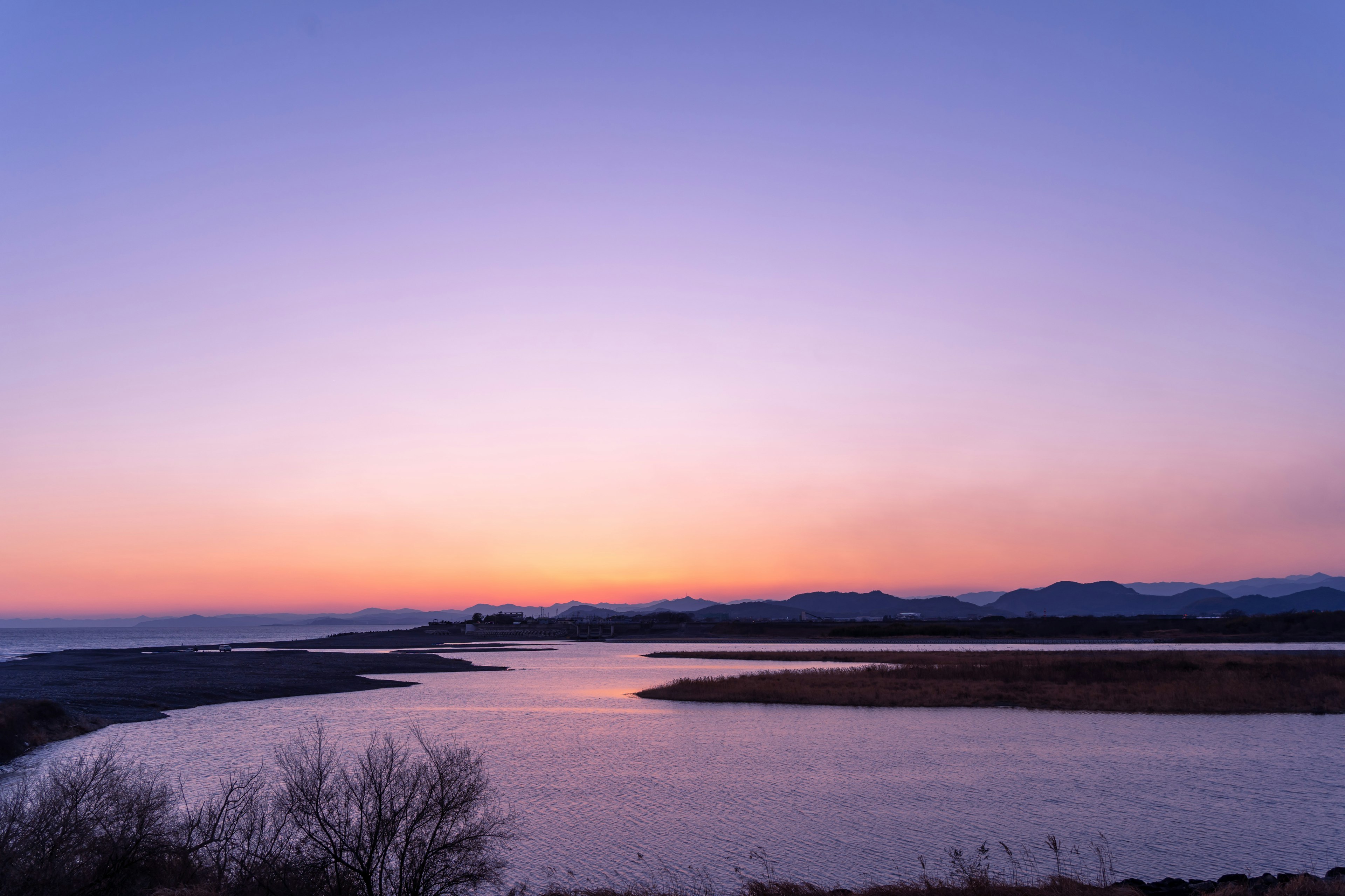 穏やかな川の流れと紫色の夕焼けの空