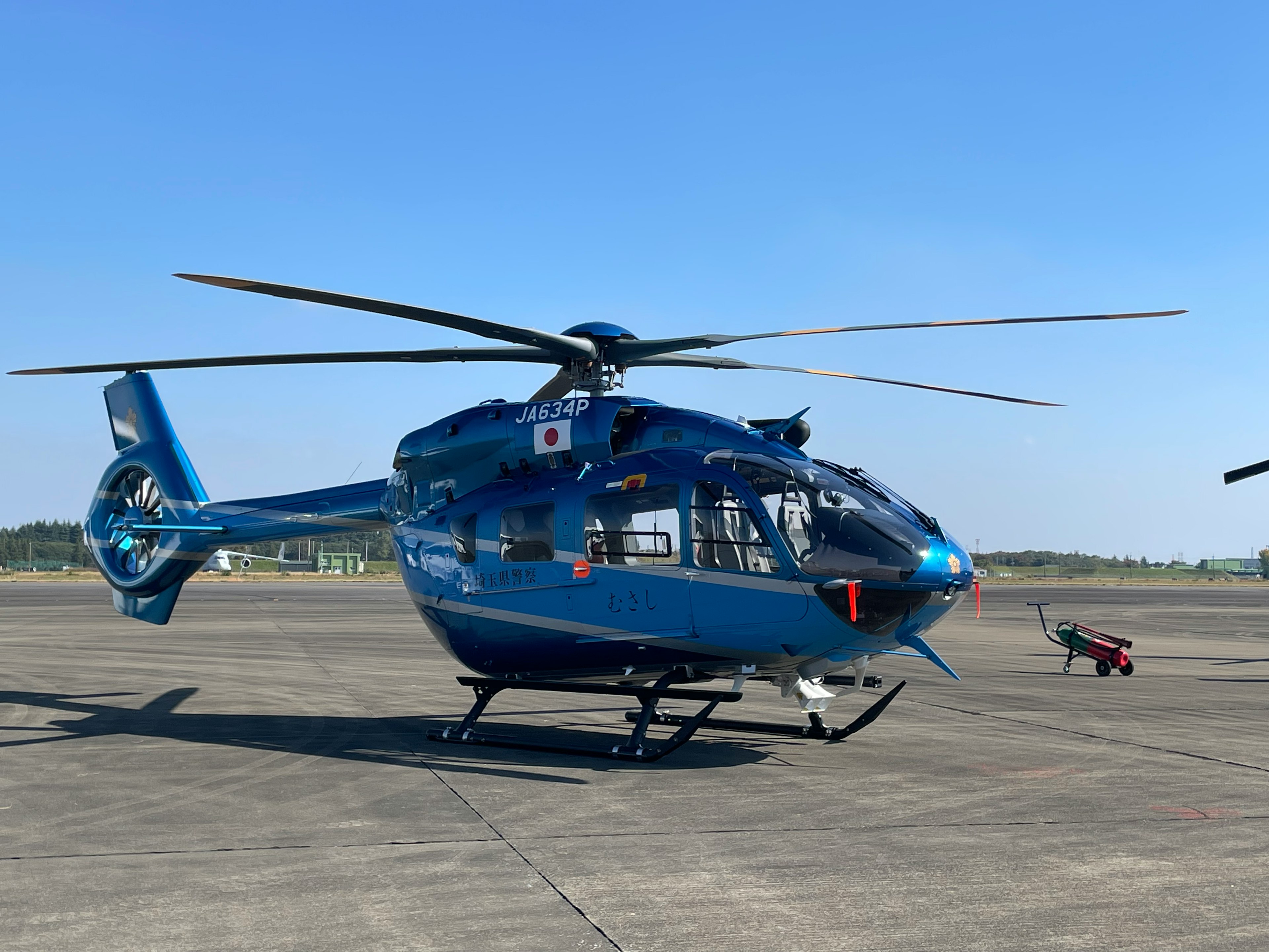 Hélicoptère bleu garé sur la piste