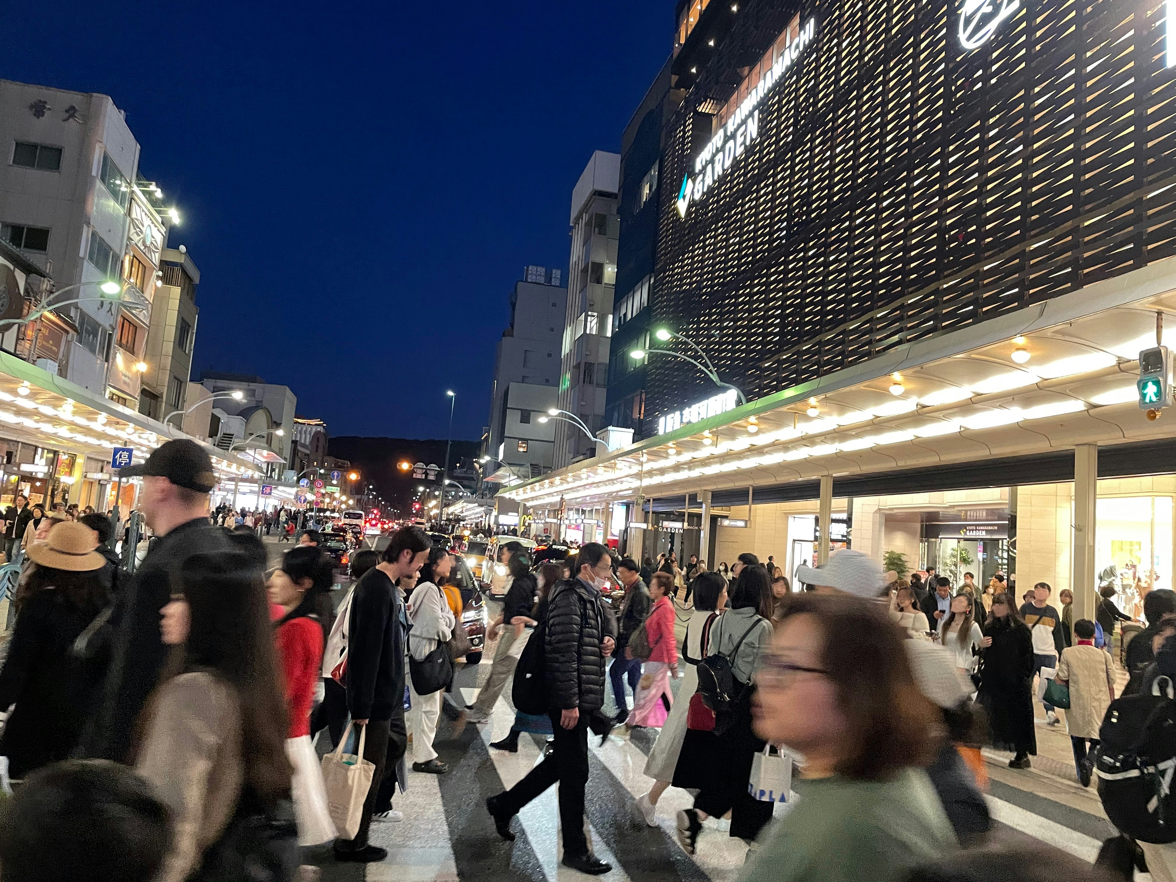 Rue commerçante animée la nuit avec des gens qui marchent