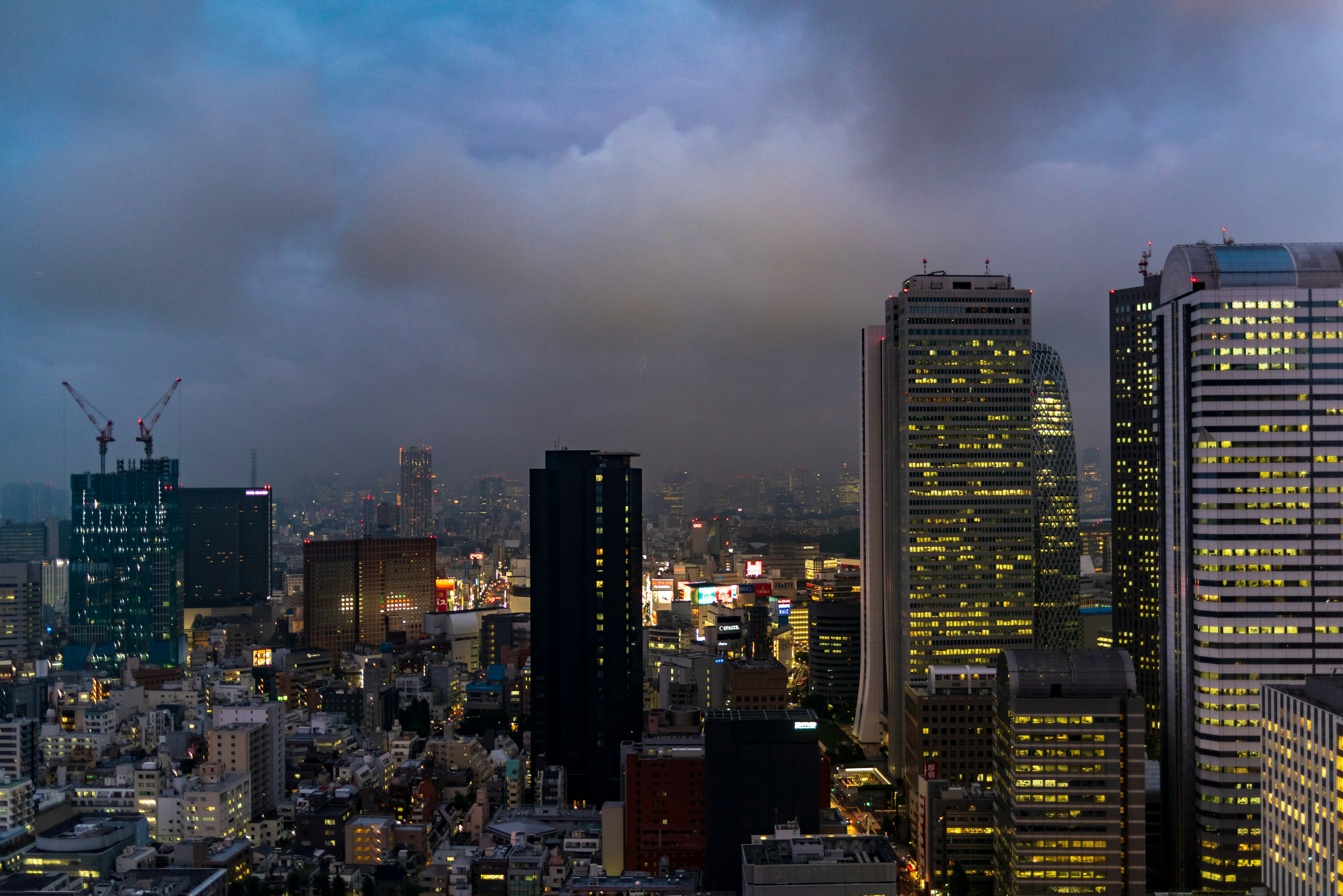 Skyline di Tokyo di notte con grattacieli e cielo nuvoloso