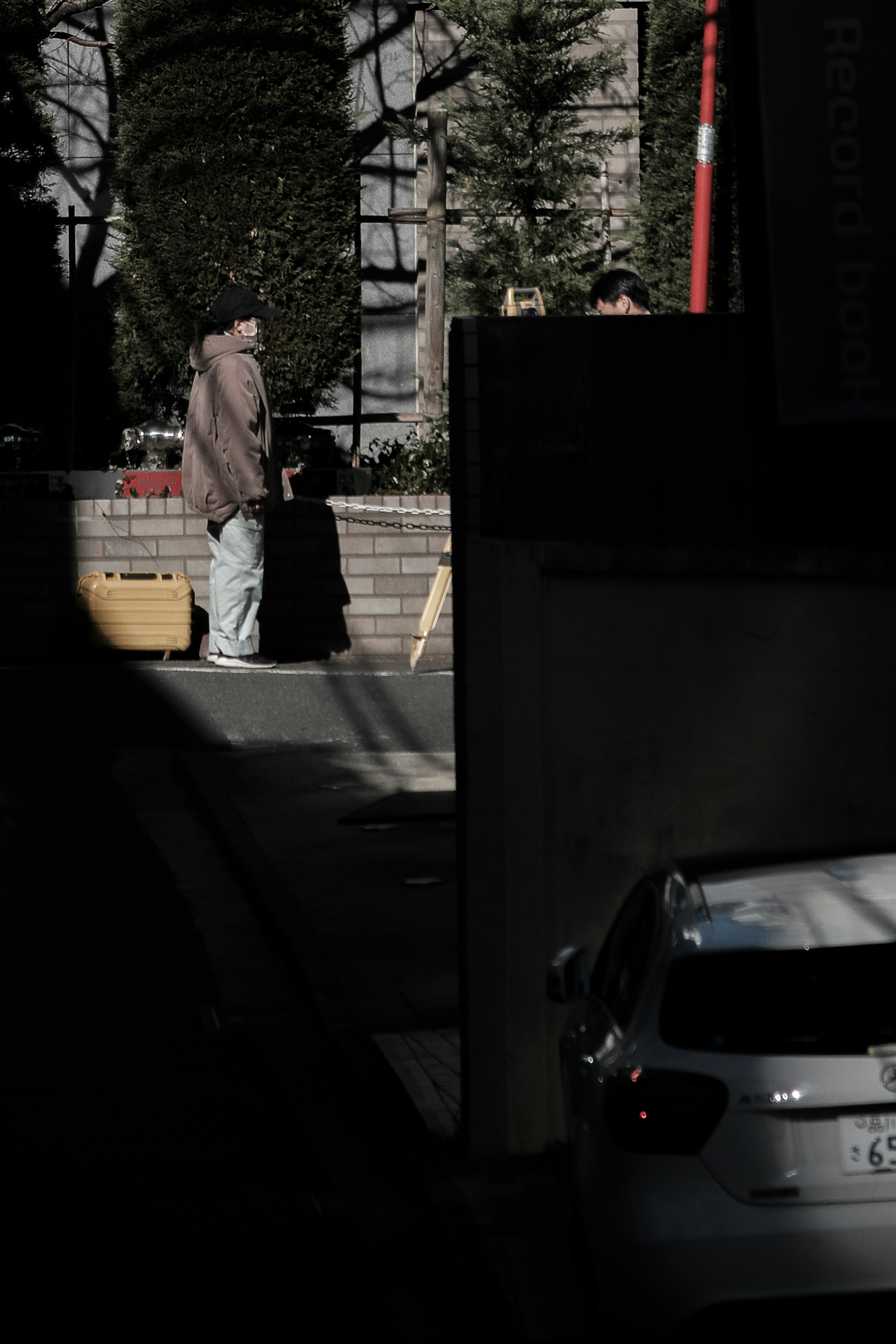 男性が街角に立ち、周囲の建物が見えるシーン