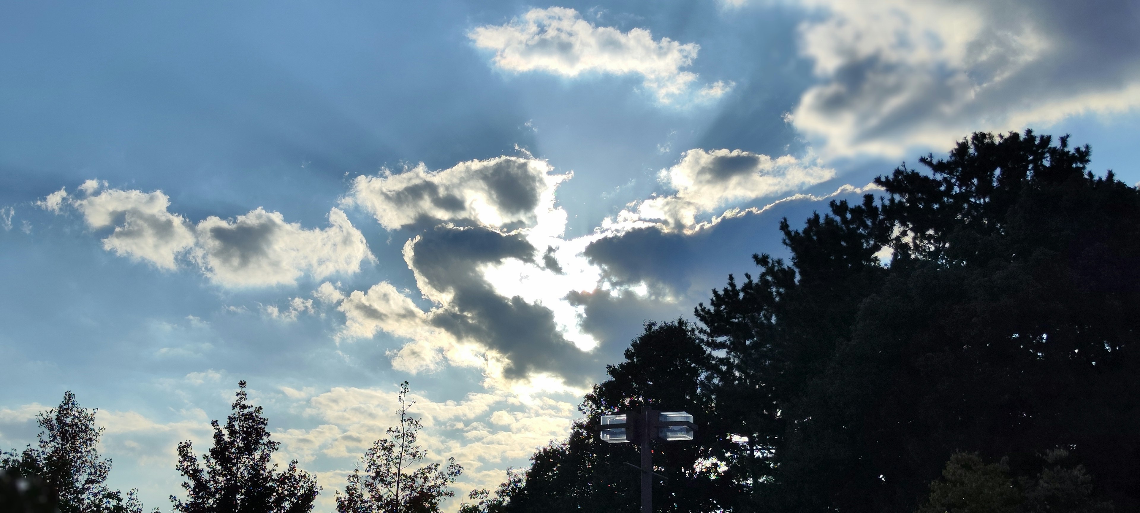 Wolken, die von Sonnenlicht in einem blauen Himmel beleuchtet werden